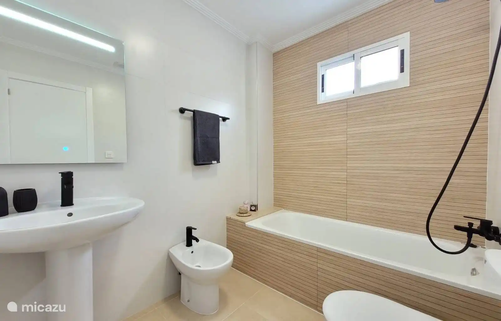 De la salle de bain à la chambre avec baignoire, toilettes et bidet.