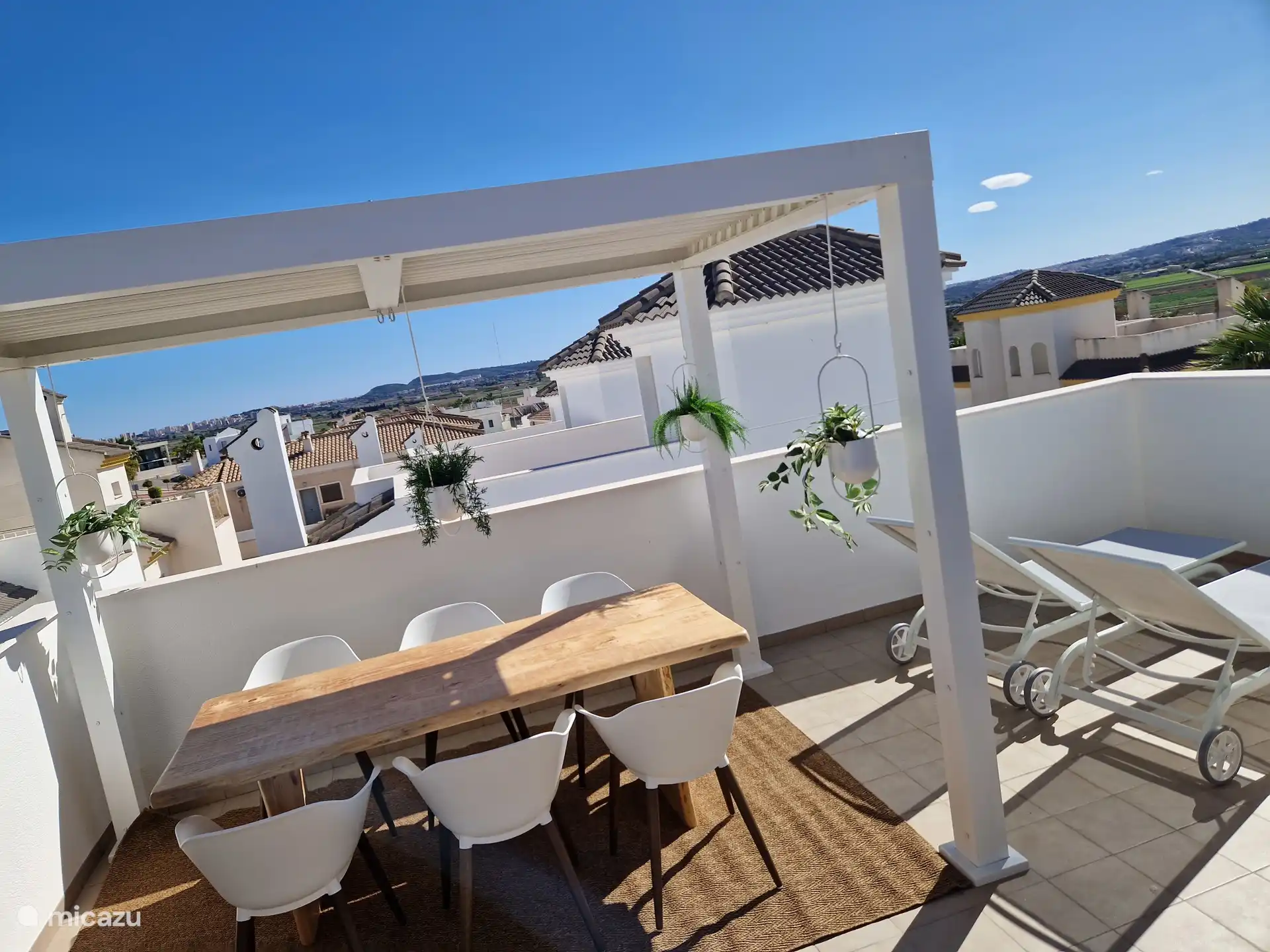 Terrasse sur le toit avec table à manger couverte.