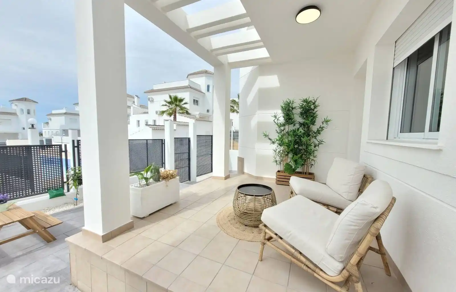 Un coin salon confortable à l’avant de la maison, avec vue sur la piscine.