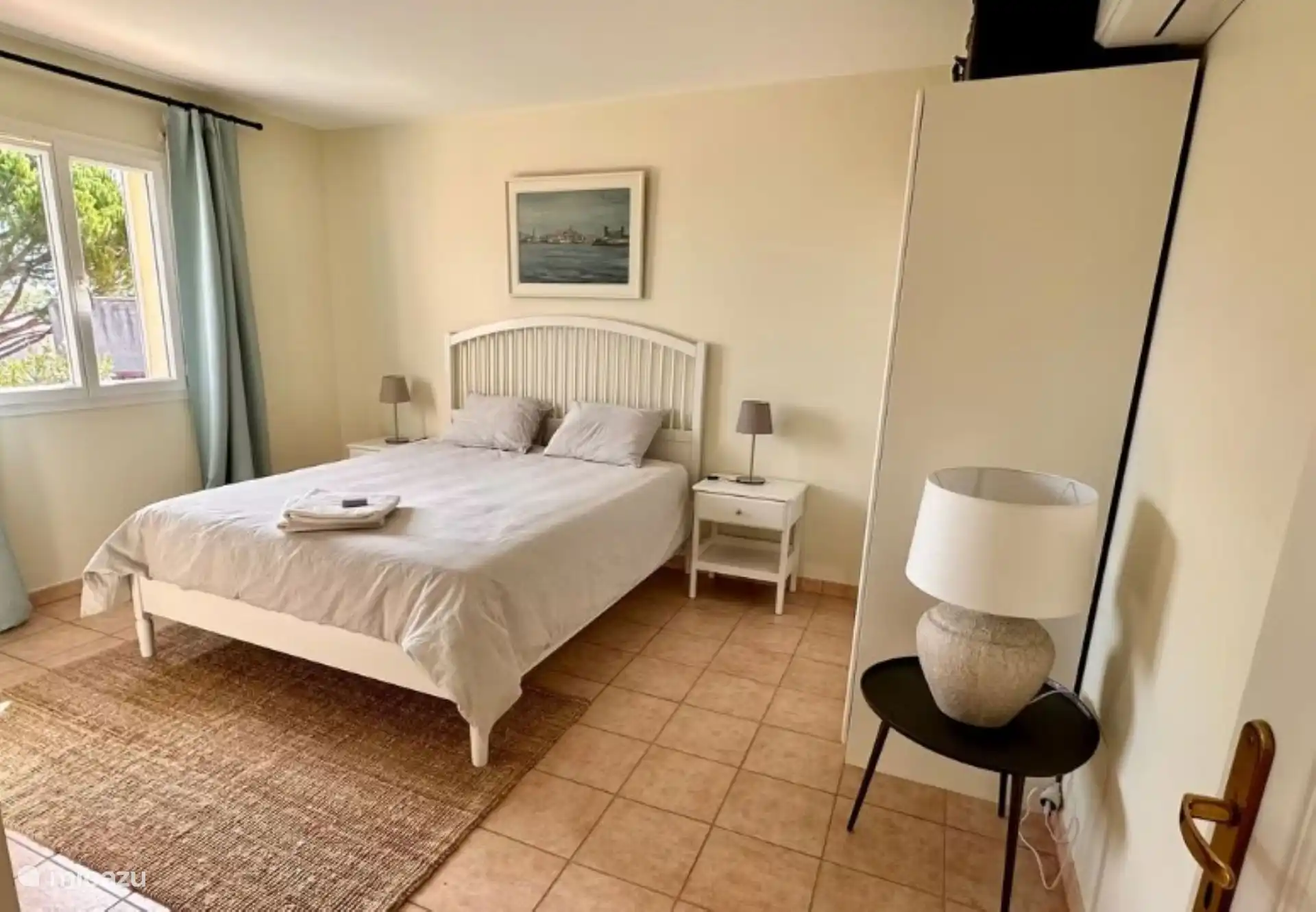 Op de witte kamer staat er ook een ruime kleerkast en er is vanuit de kamer zicht op de aanpalende olijvengaard