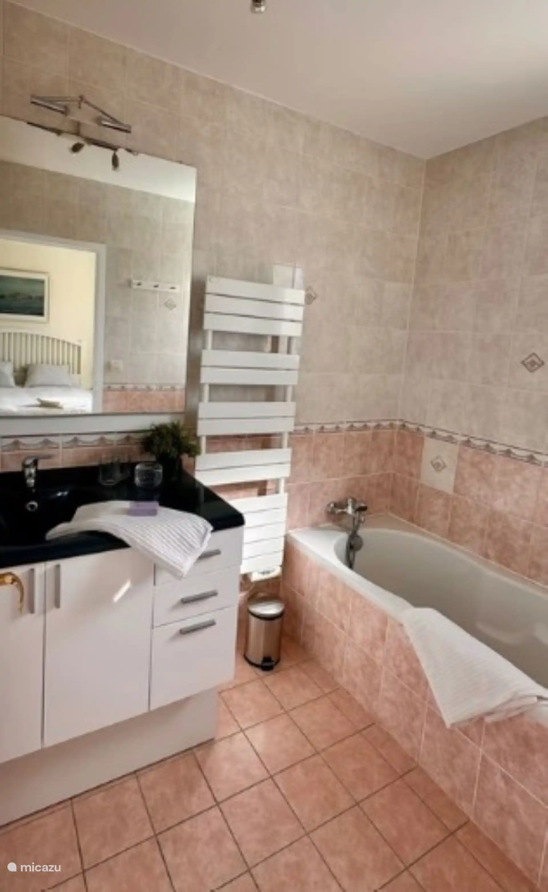 Deze badkamer sluit aan op de grote witte slaapkamer op de eerste verdieping met ligbad/douche en wastafel 