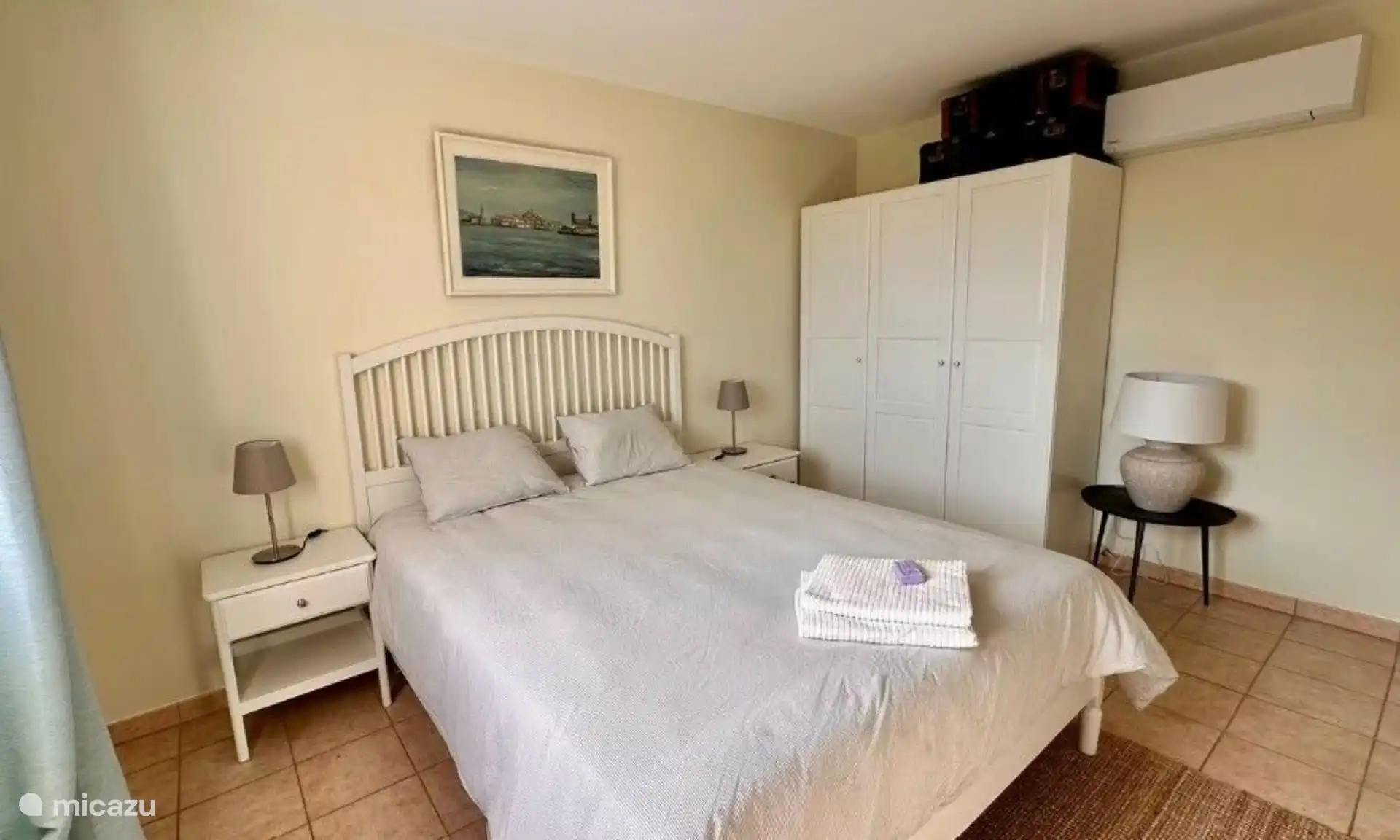 Grote witte slaapkamer met airco op de verdieping