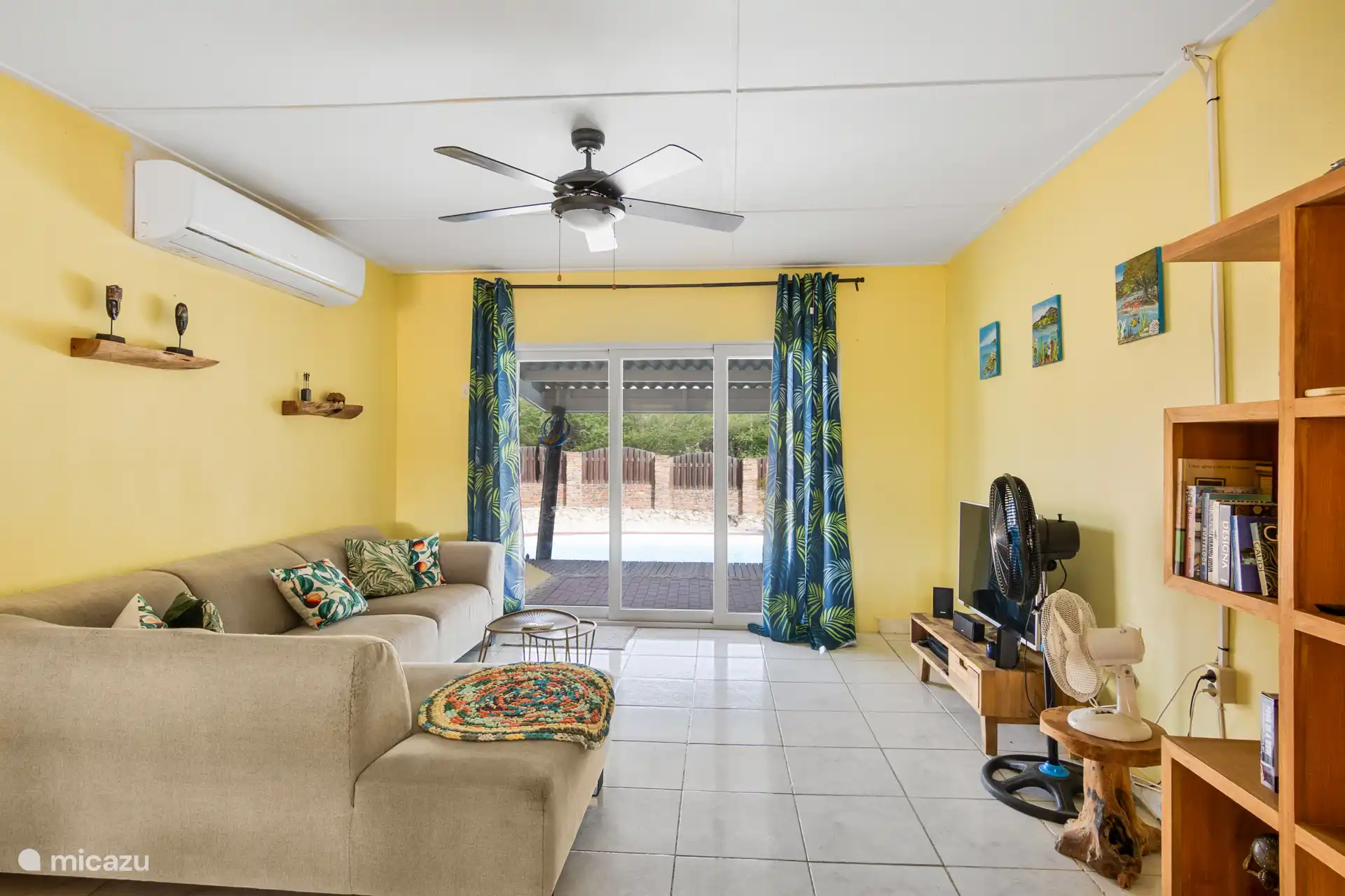 Woonkamer met smart TV, airco, en ventilatoren