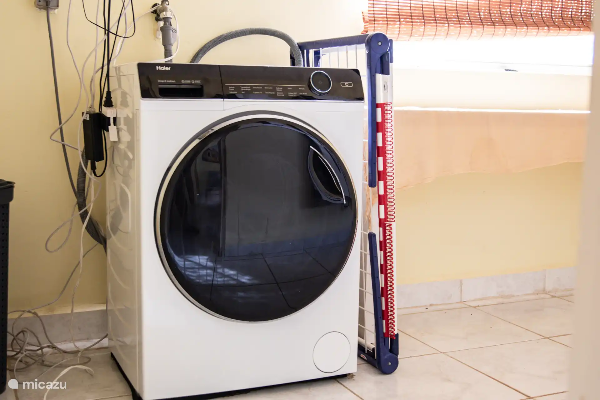 Wasruimte met wasmachine en droogrek