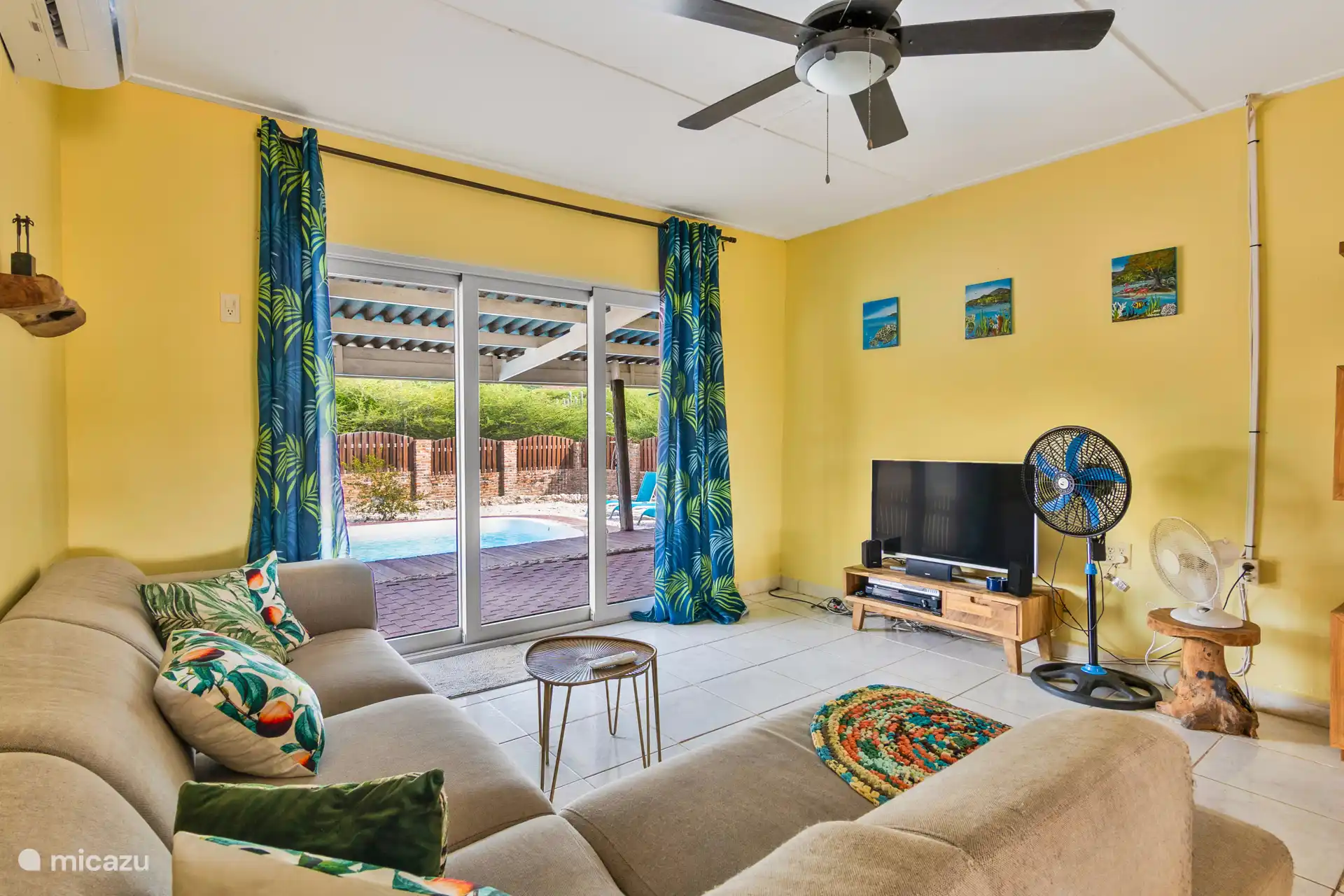 Woonkamer met smart TV, airco, en ventilatoren