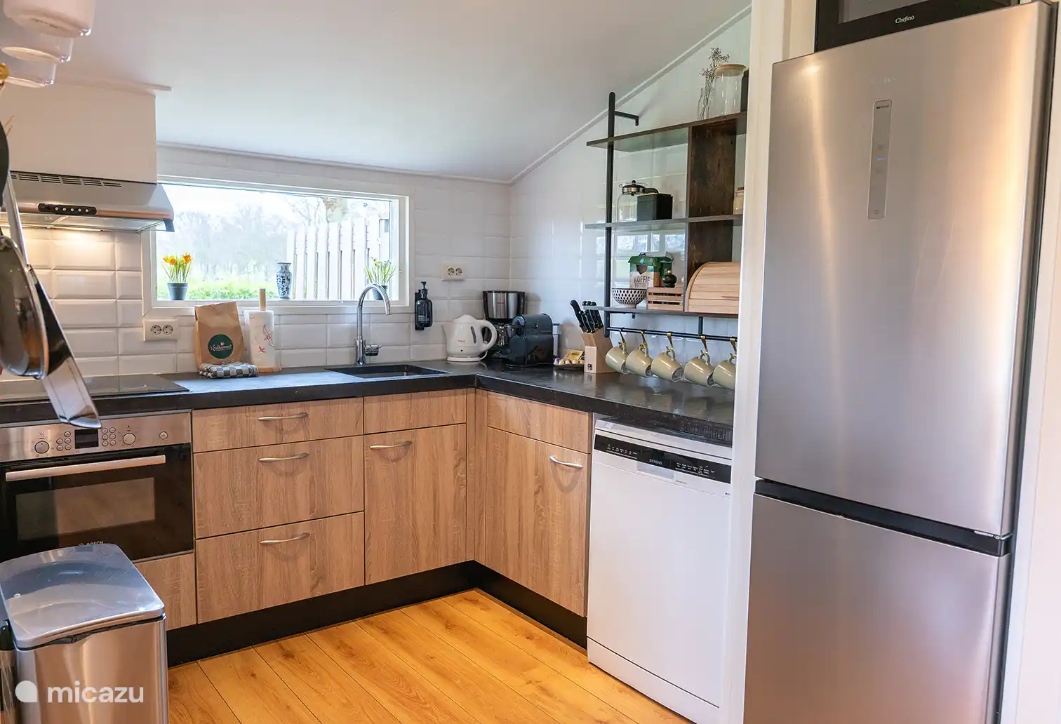 Keuken met vaatwasser, inductiekookplaat, combimagnetron, grote koelkast en wijnklimaatkast