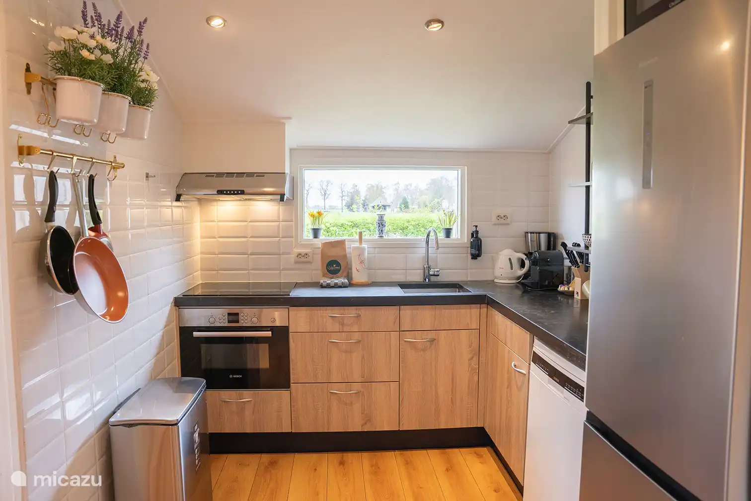 Keuken prachtig uitzicht over het weiland. De keuken is uitgerust met een vaatwasser, inductiekookplaat, combimagnetron, grote koelkast en wijnklimaatkast