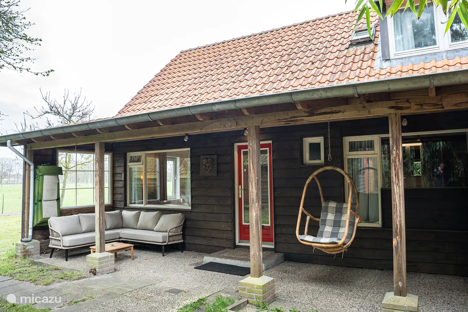 Veranda met loungeset en hangende stoel