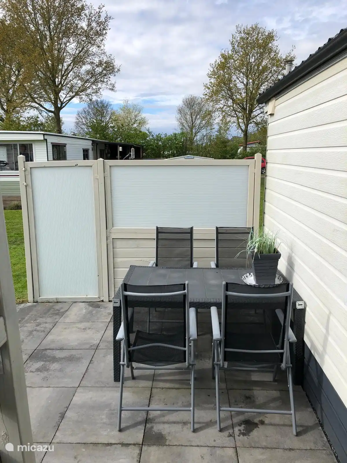 Zona de comedor exterior en la terraza con biombo de privacidad.