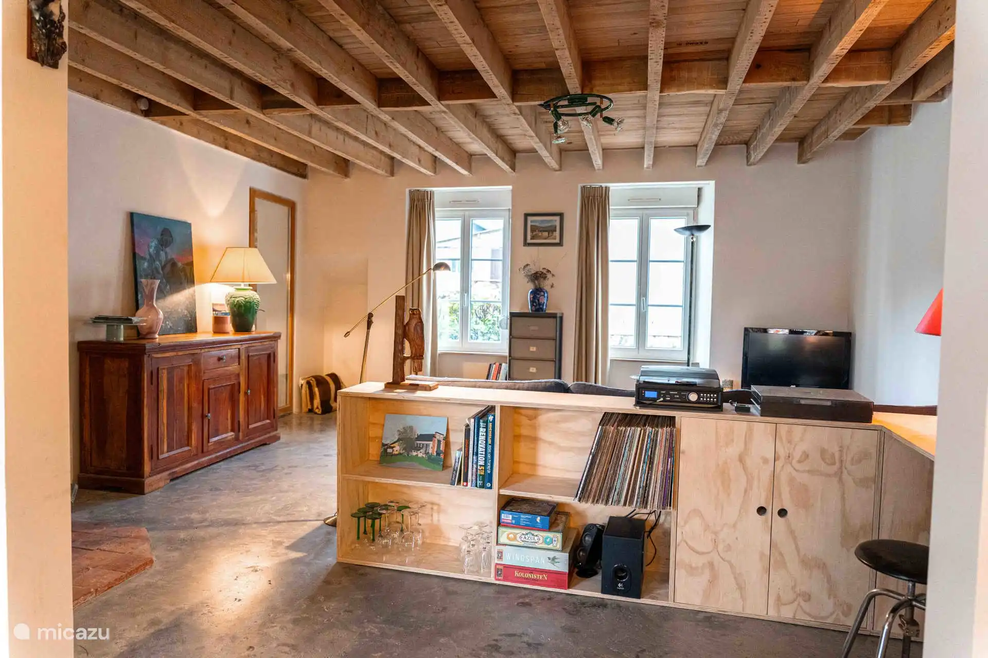 De fijne woonkamer met spelletjes, muziekinstallatie, platenspeler, boeken en een televisie