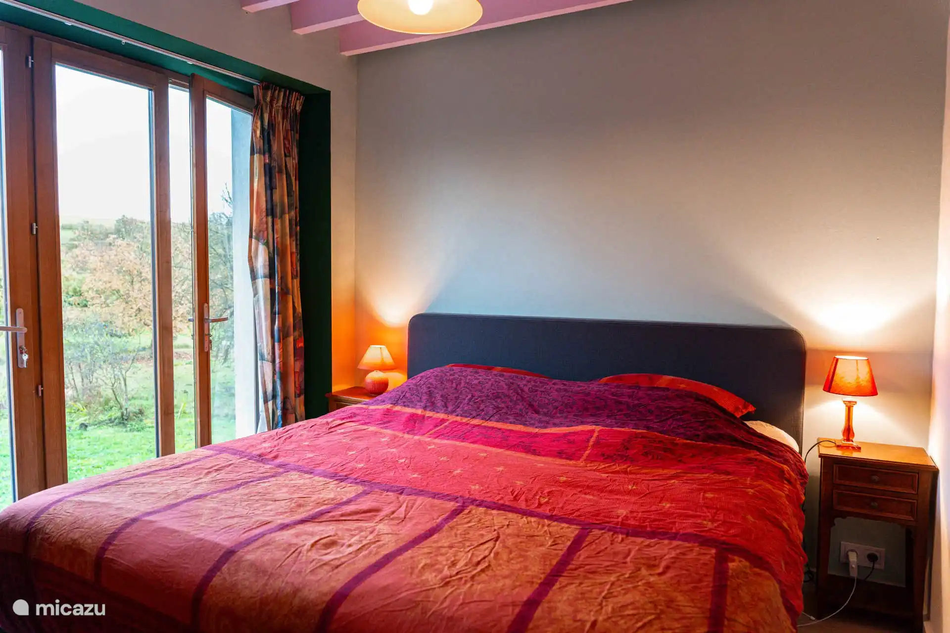 De roze slaapkamer, met een tweepersoonsbed en een bureau