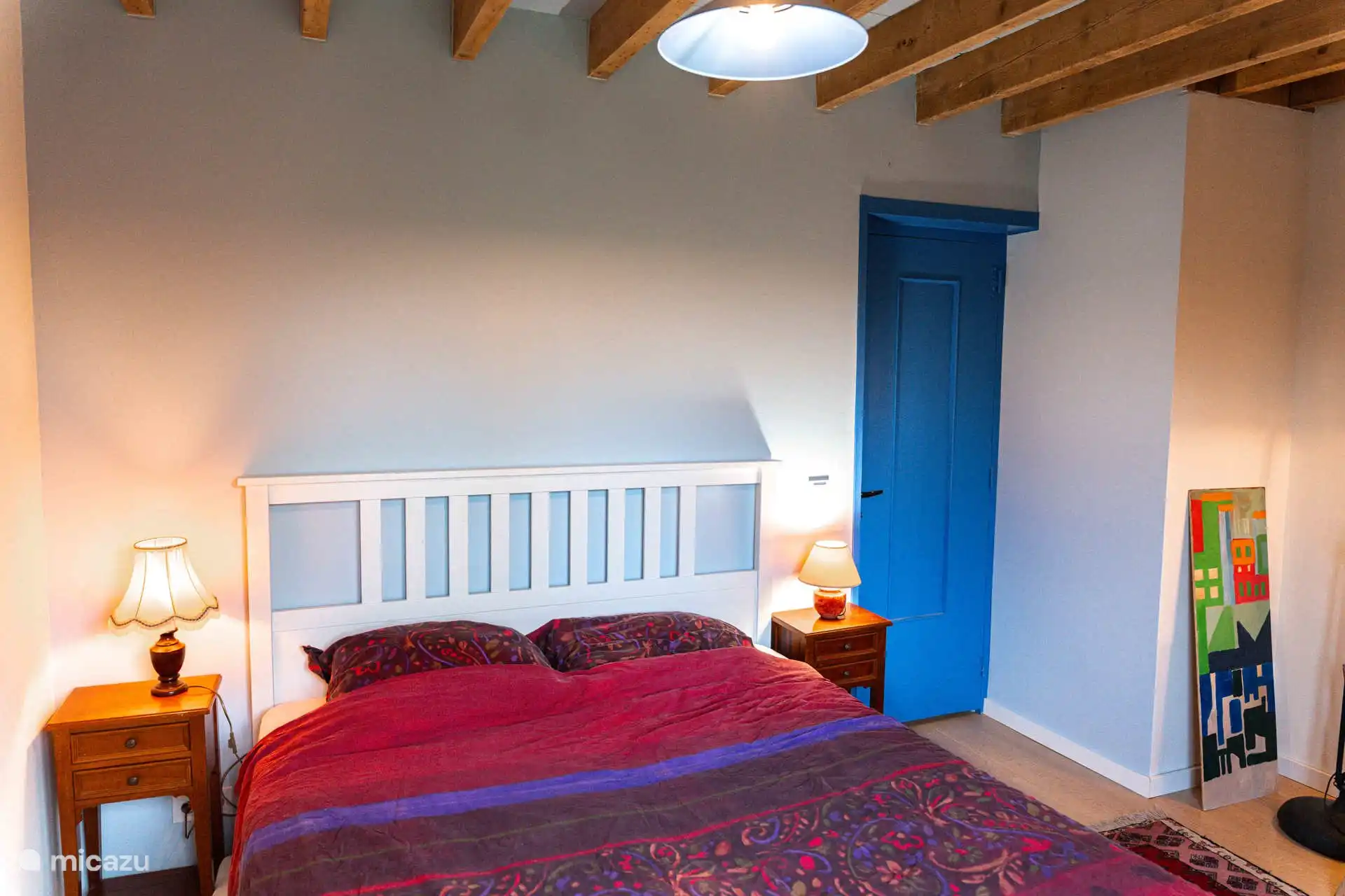 De blauwe slaapkamer, met een tweepersoonsbed en een bureau