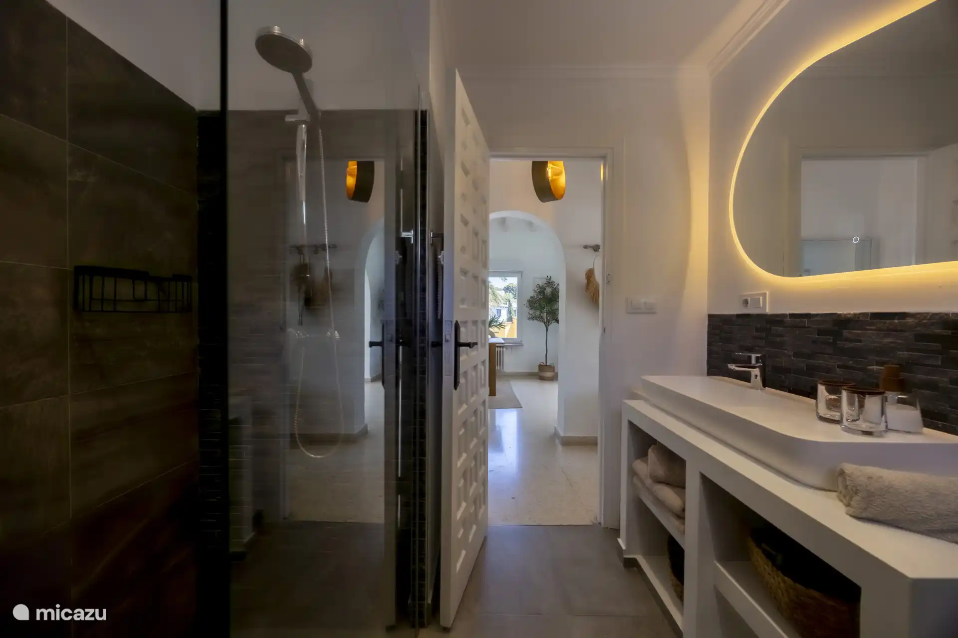 Badkamer met een douche, toilet en enkele wastafel.