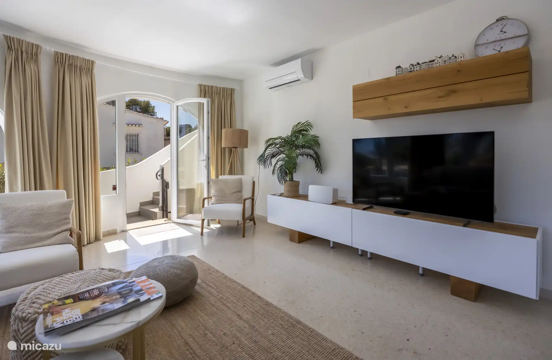 Hier kom je in een stijlvolle woonkamer met airco, Nederlandse televisie en een Sonos Five, perfect voor een ontspannen avond met muziek of een film.