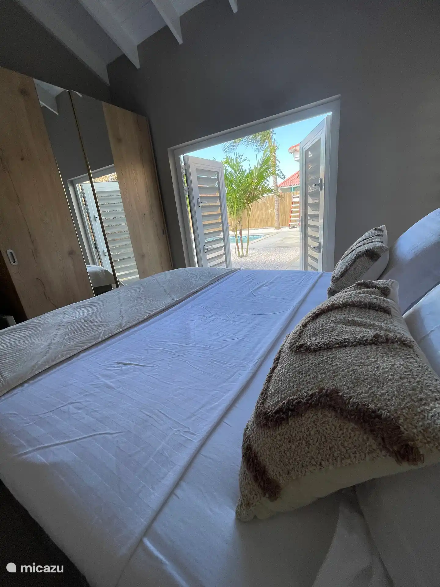 De slaapkamer heeft openslaande deuren met uitzicht op de tuin/zwembad. Een Kingsize bed van 180x210 cm, een ruime kledingkast, badkamer/regendouche/toilet, airco en plafondventilator. 