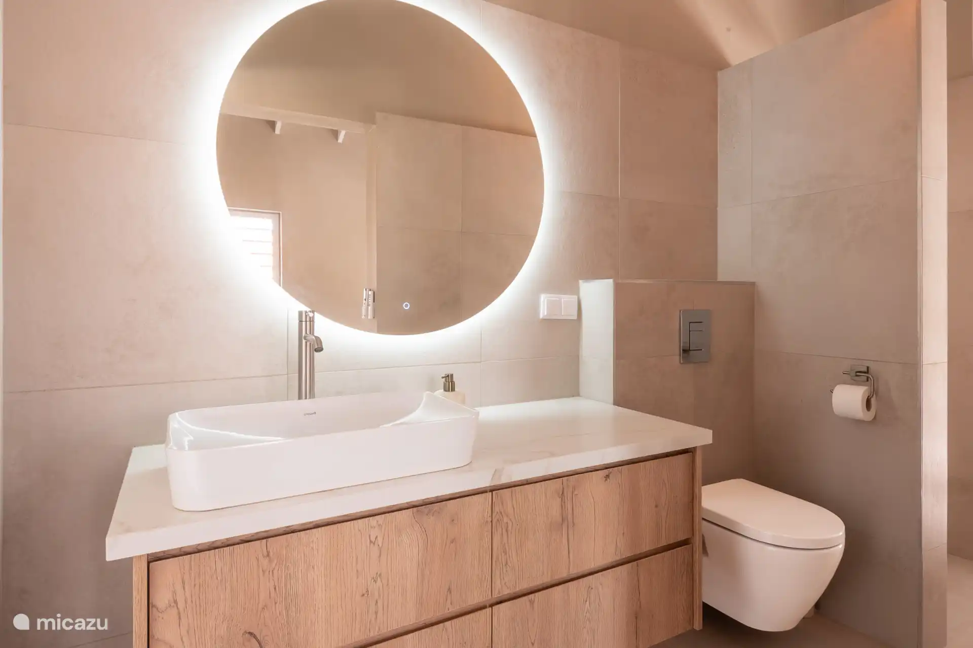 Wasmeubele met mooie verlichte spiegel, toilet en regendouche.