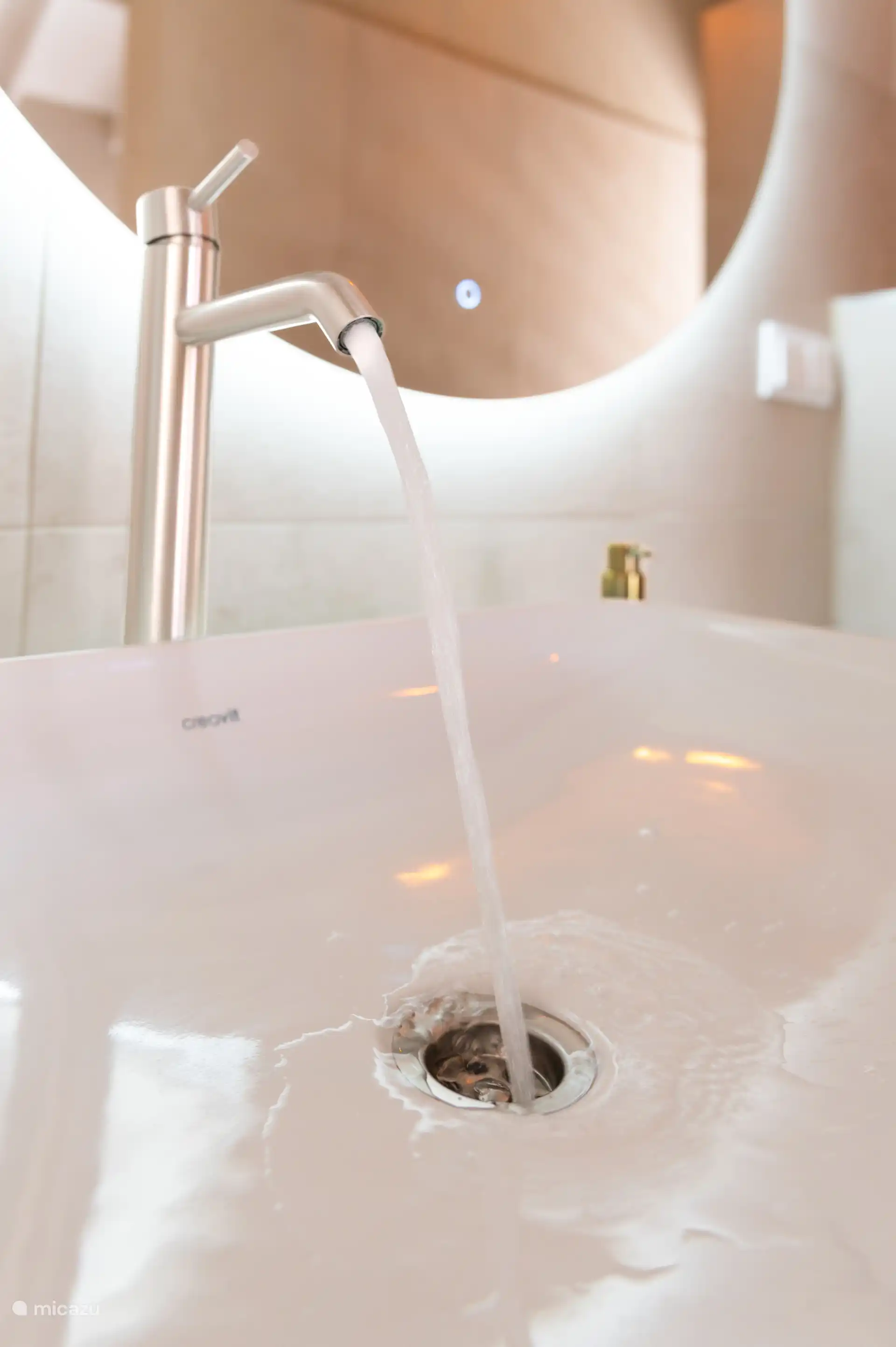 wastafel met grote verlichte spiegel