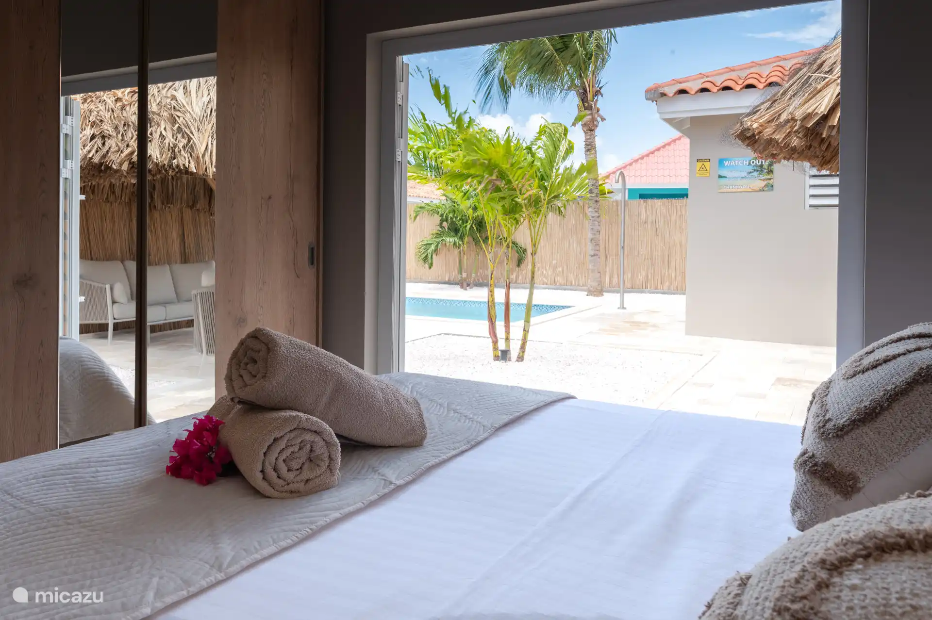 El dormitorio principal tiene puertas de patio, así que puedes disfrutar de las vistas de la piscina y las palmeras.