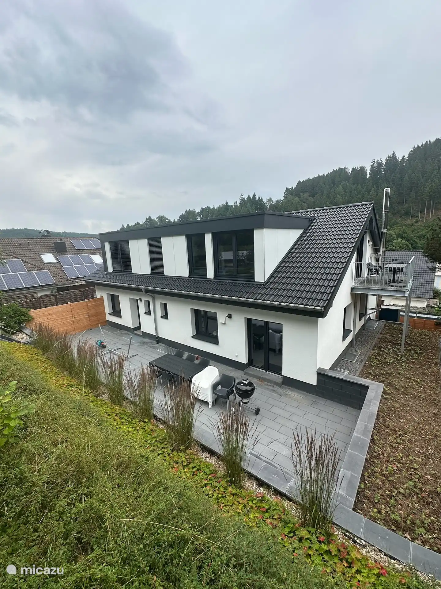 Achterzijde Villa Brachfeld en groot terras en opgang naar de tuin