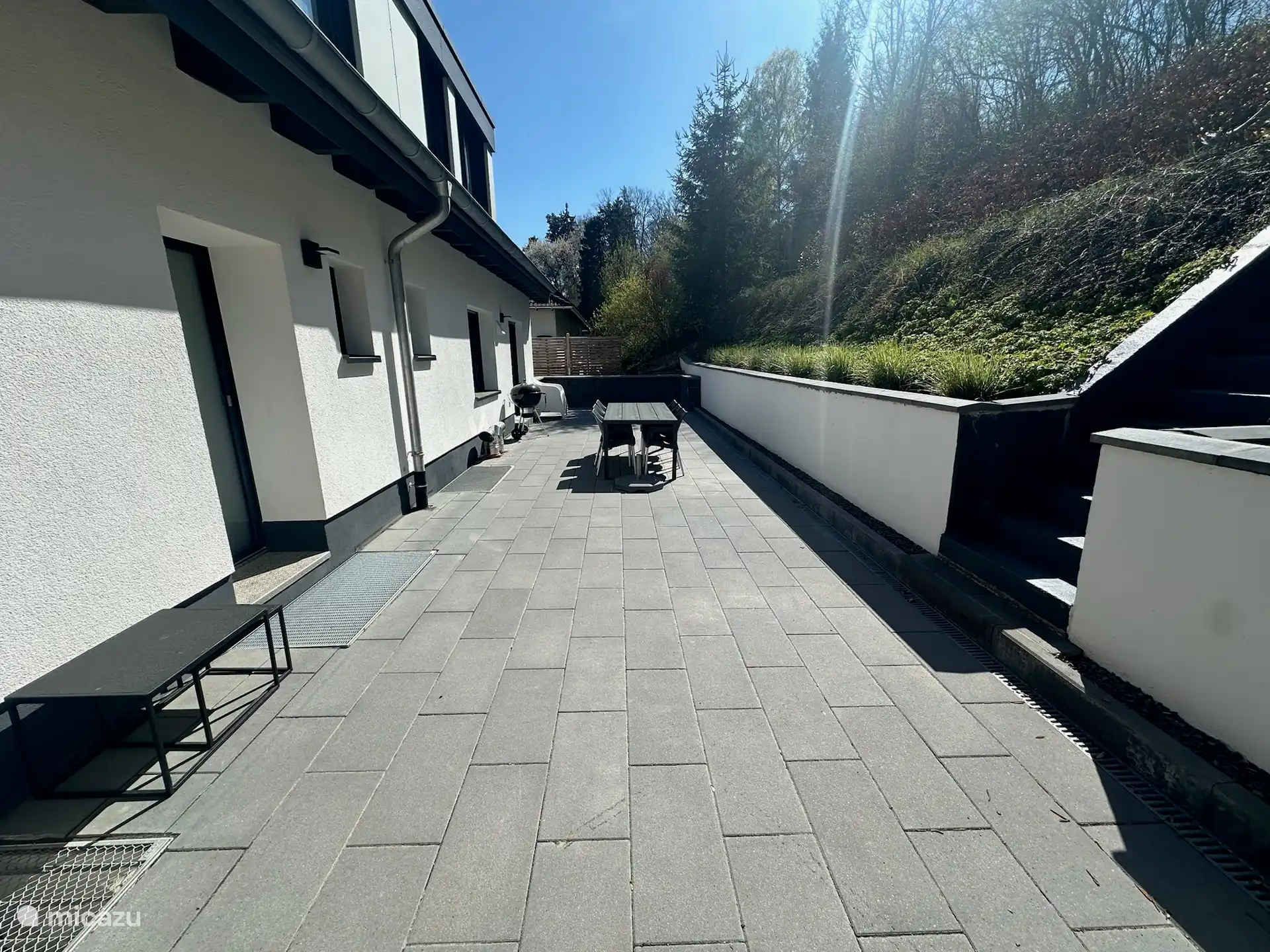 Terrasse avec une grande table à manger, chaises longues et Weber BBQ !