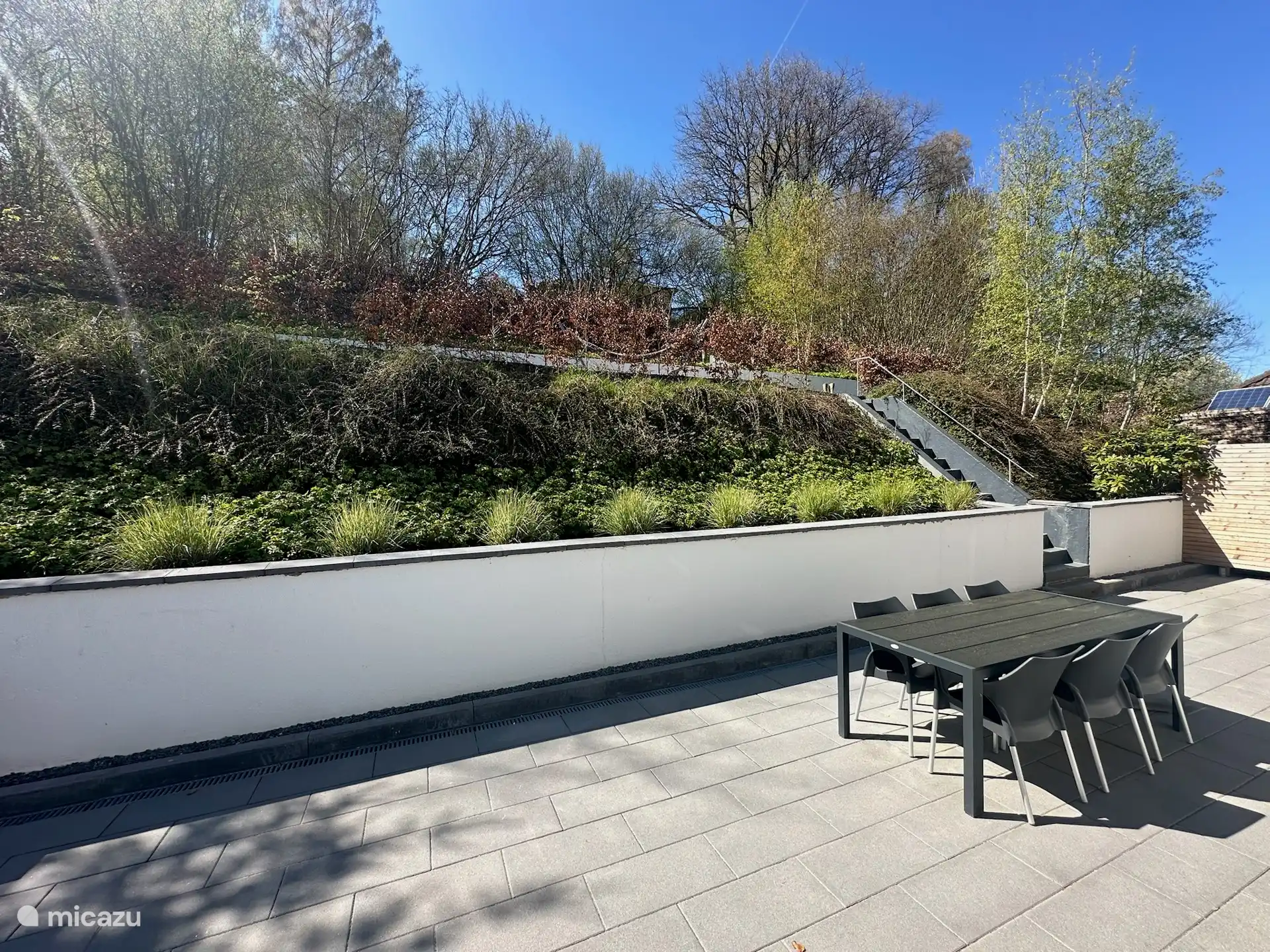 Terrasse avec une grande table à manger, chaises longues et Weber BBQ !