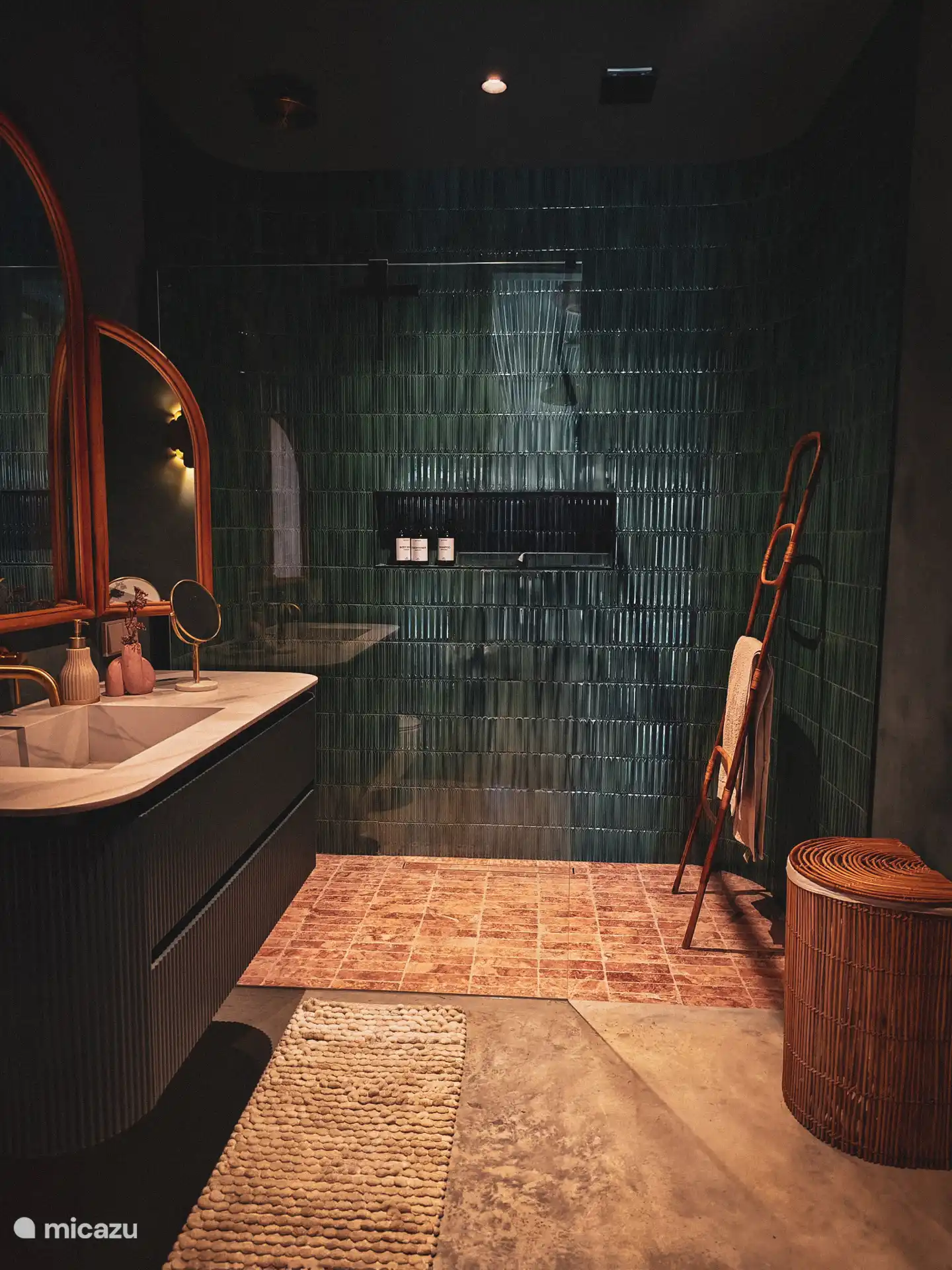 Shared bathroom, organically shaped in deep petrol blue tones.