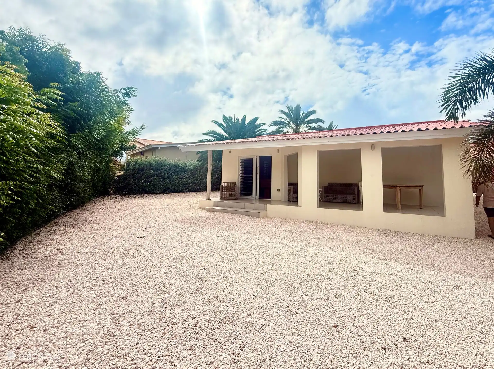 Achteraanzicht van de woning vanuit de tuin met veel privacy: ruime overdekte porch op de wind. 