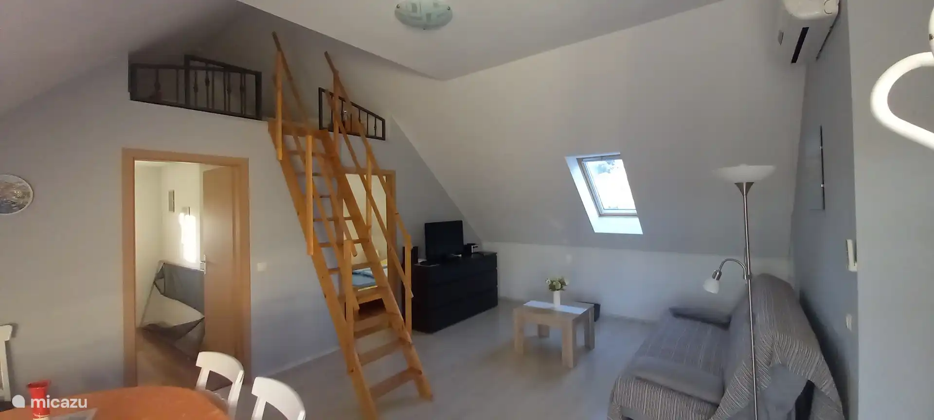 Salon salon avec escaliers menant au loft