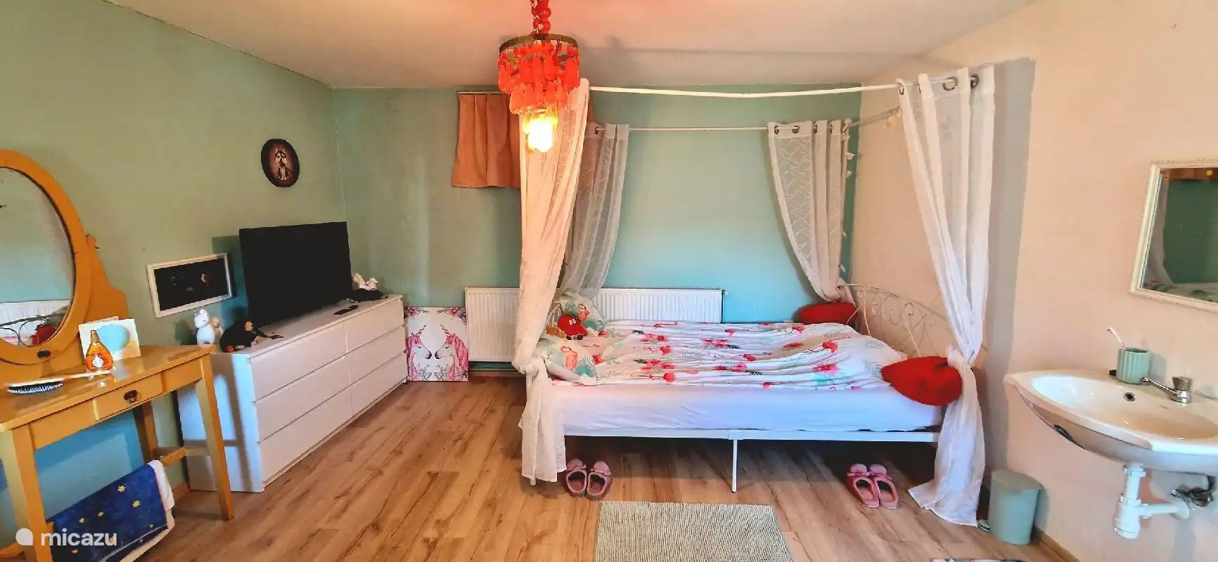 Slaapkamer met nieuw parketvloer, verduisteringsgordijnen en open deur naar de schitterende tuin. Tv met Netflix biedt de mogelijkheid om een serie te kijken in bed