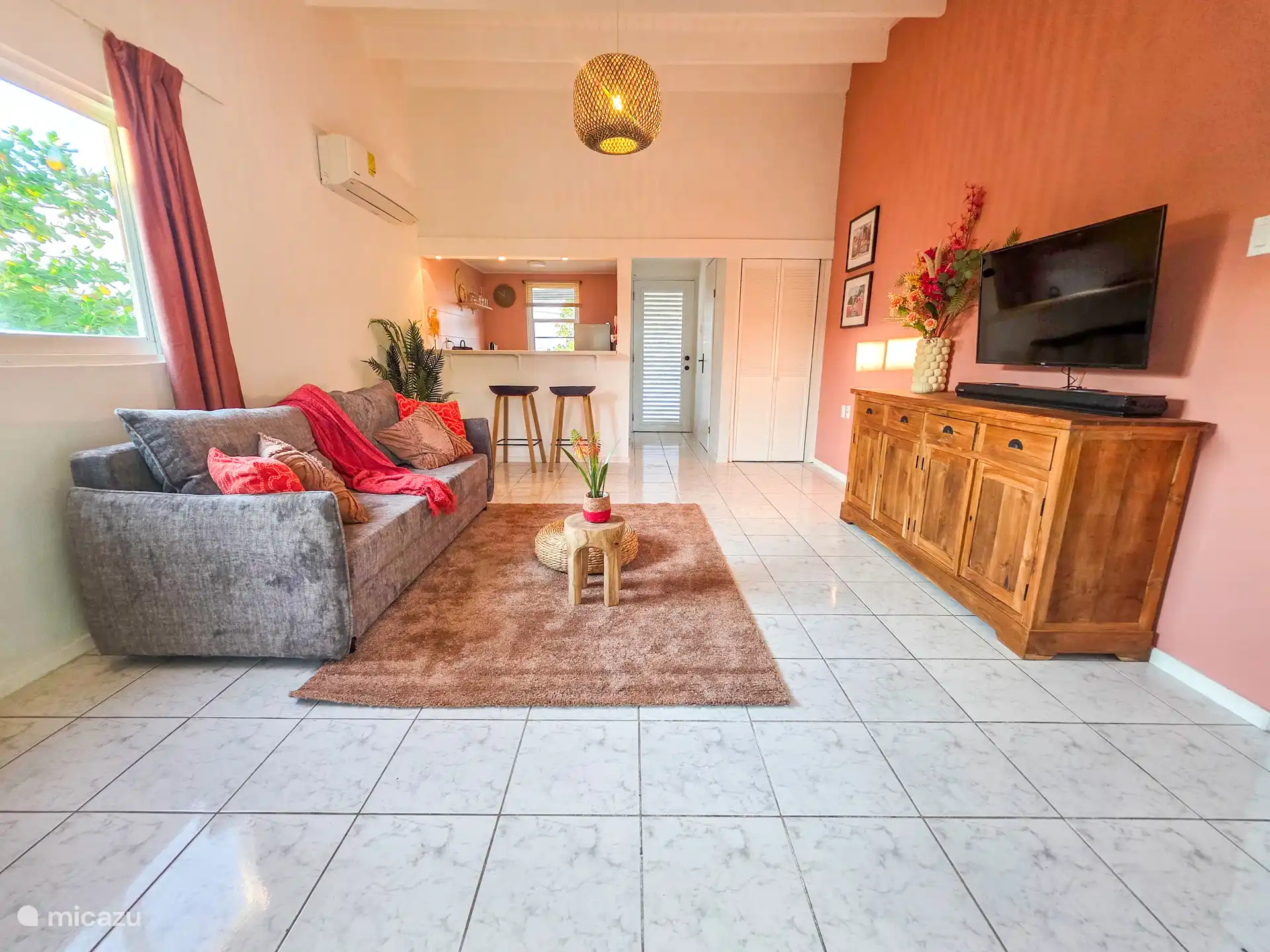 In de open woonkamer kun je heerlijk relaxen op de comfortabele bank, omringd door smaakvolle decoraties en een uitnodigende ambiance. 