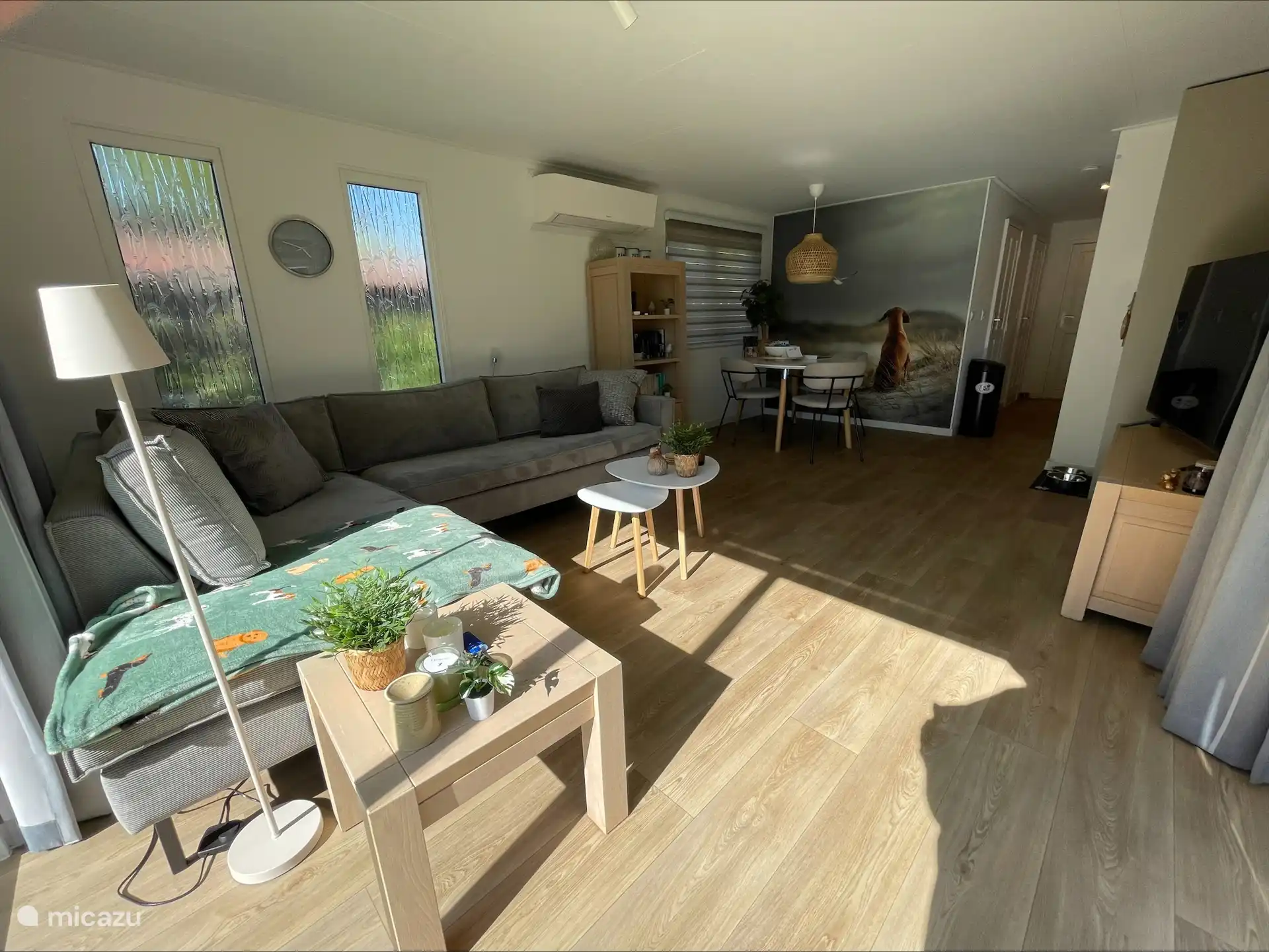 El salón está amueblado con un cómodo sofá de esquina y una mesa de comedor, y dispone de una smart TV y aire acondicionado.