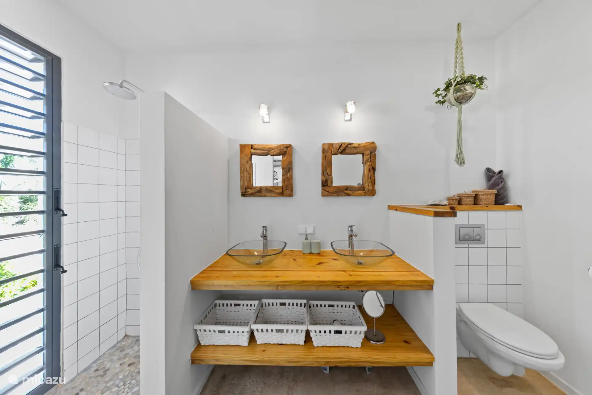 Badkamer bij de master slaapkamer, met twee wastafels, toilet en douche