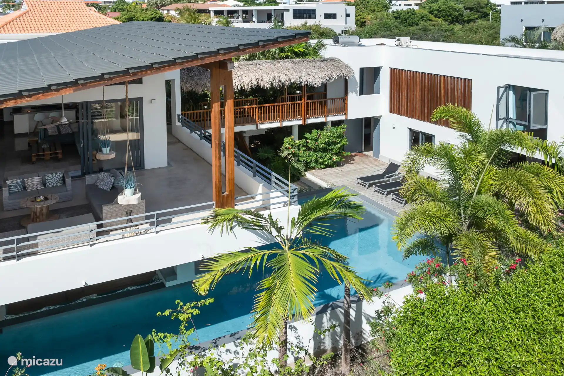 Foto zijkant huis, waar ook valt te zien hoe de veranda ligt en het zwembad ook nog daaronder loopt