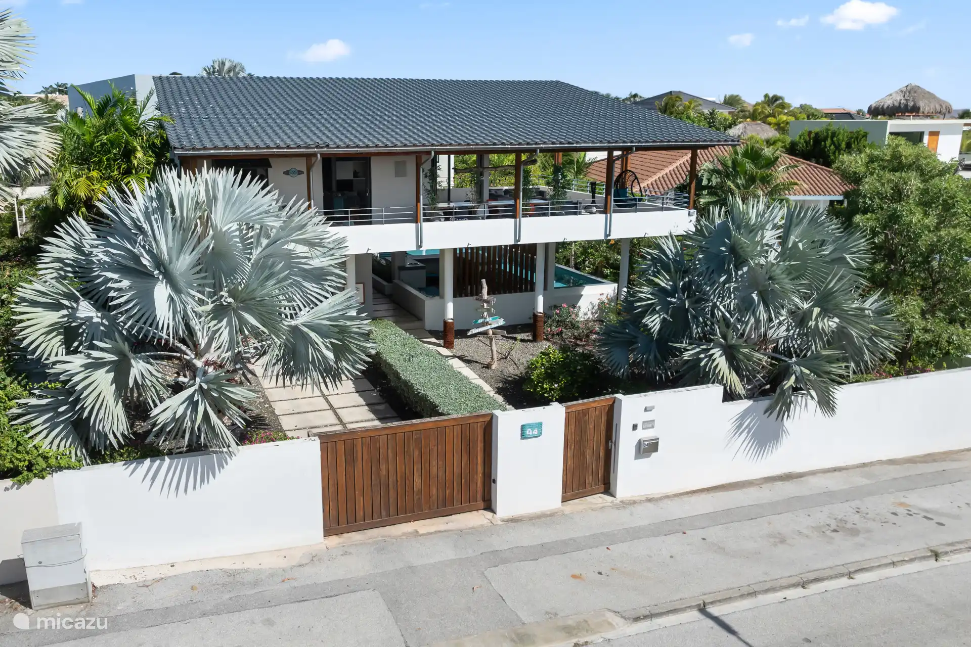 Voorkant huis, met in de voortuin twee prachtige bomen. Aan de zijkant en achterkant ook veel groen