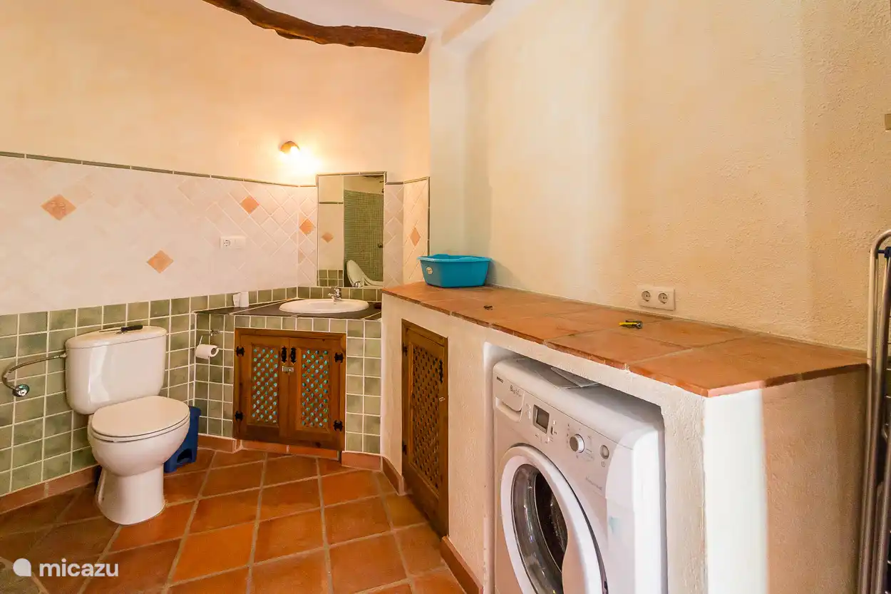 Gezamenlijke extra badkamer met toilet, douche en wasmachine (naast het zwembad).