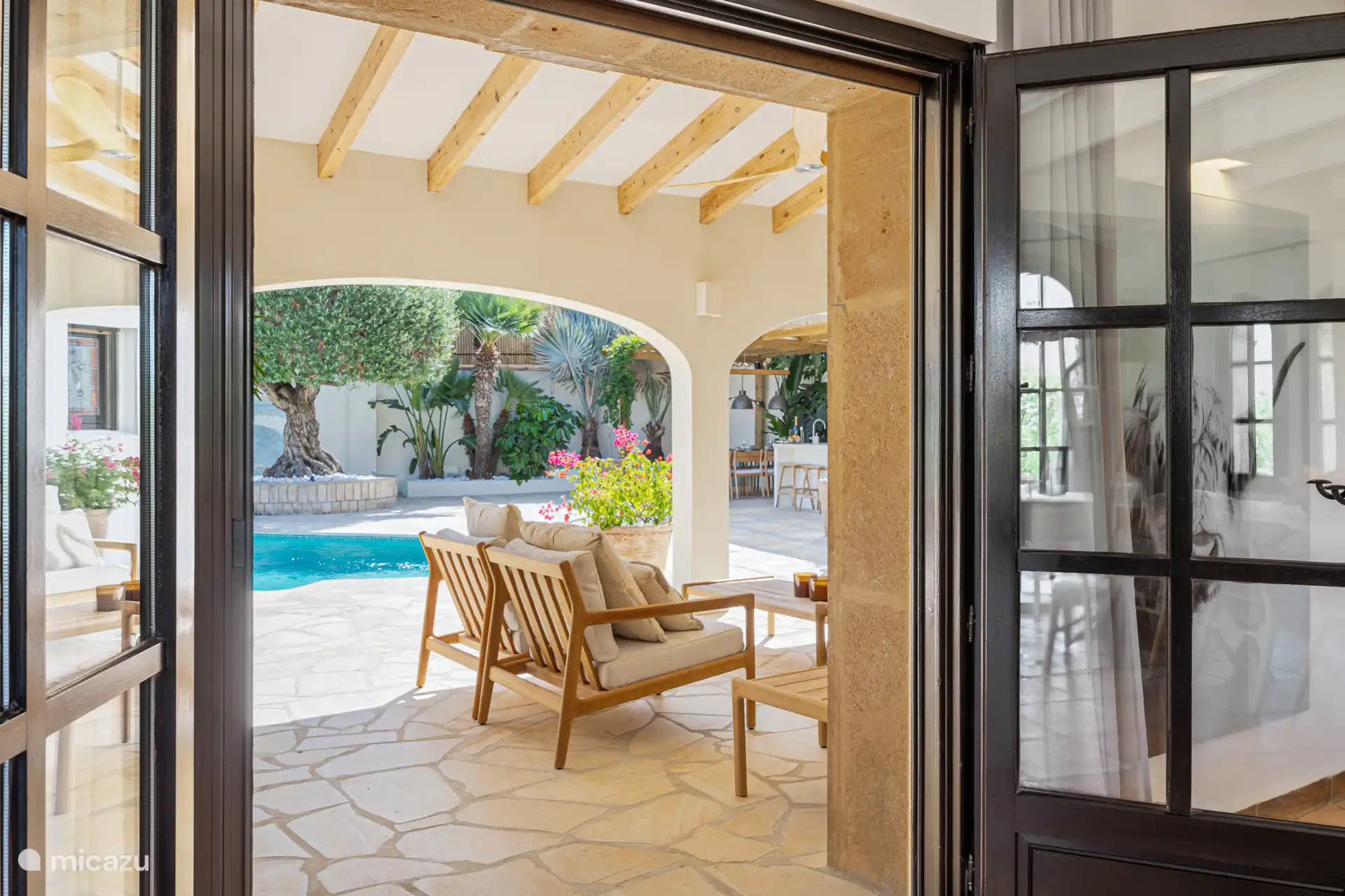 Van binnen naar buiten.....opslaande deuren vanuit de huiskamer naar een zalig ruim overdekt terras met comfortabele lounge meubelen.