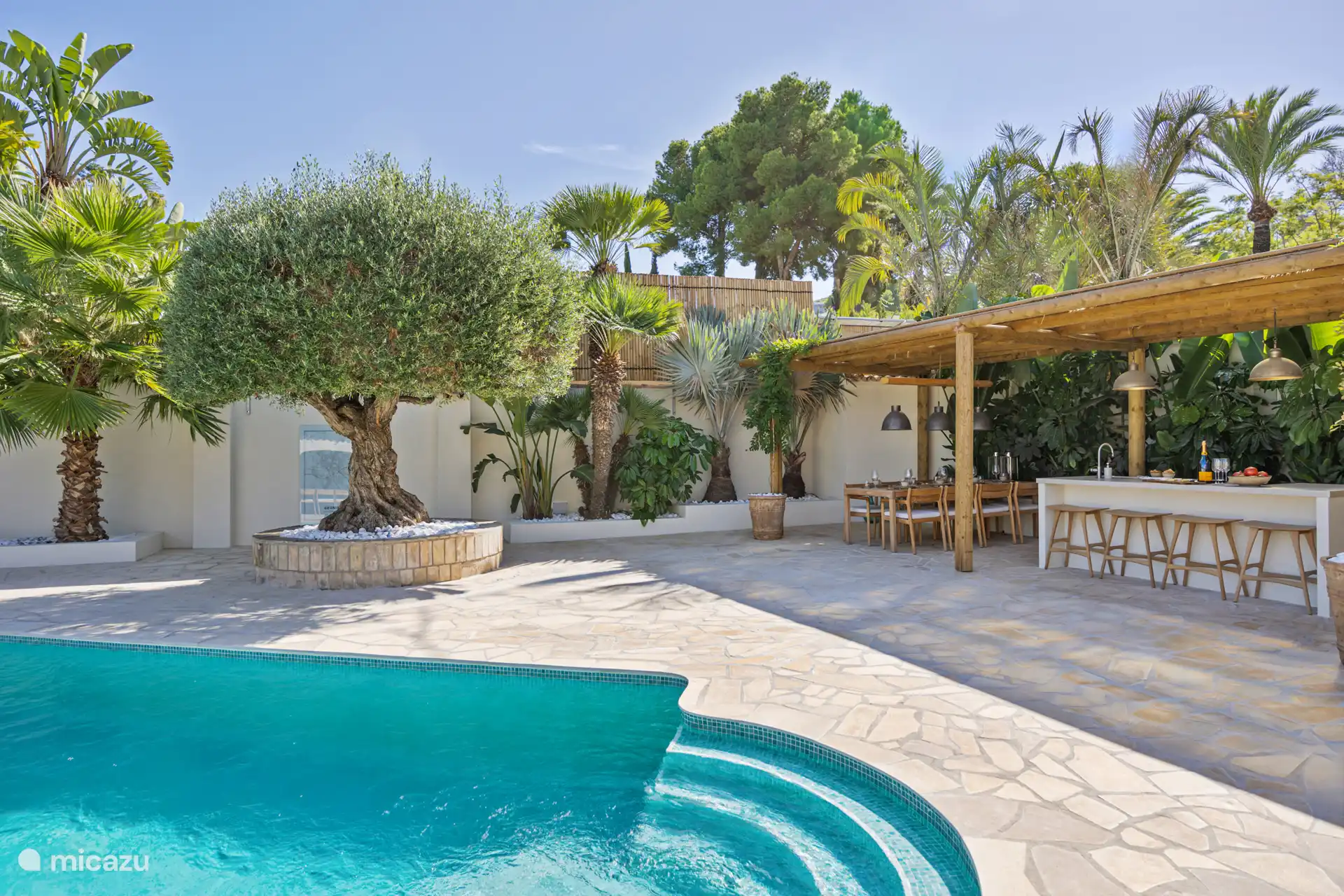 Heerlijk ruim terras rondom het zwembad, met volop ruimte en privacy, omgeven door prachtige beplanting zodat u ontspannen geniet zonder dicht op elkaar te zitten.