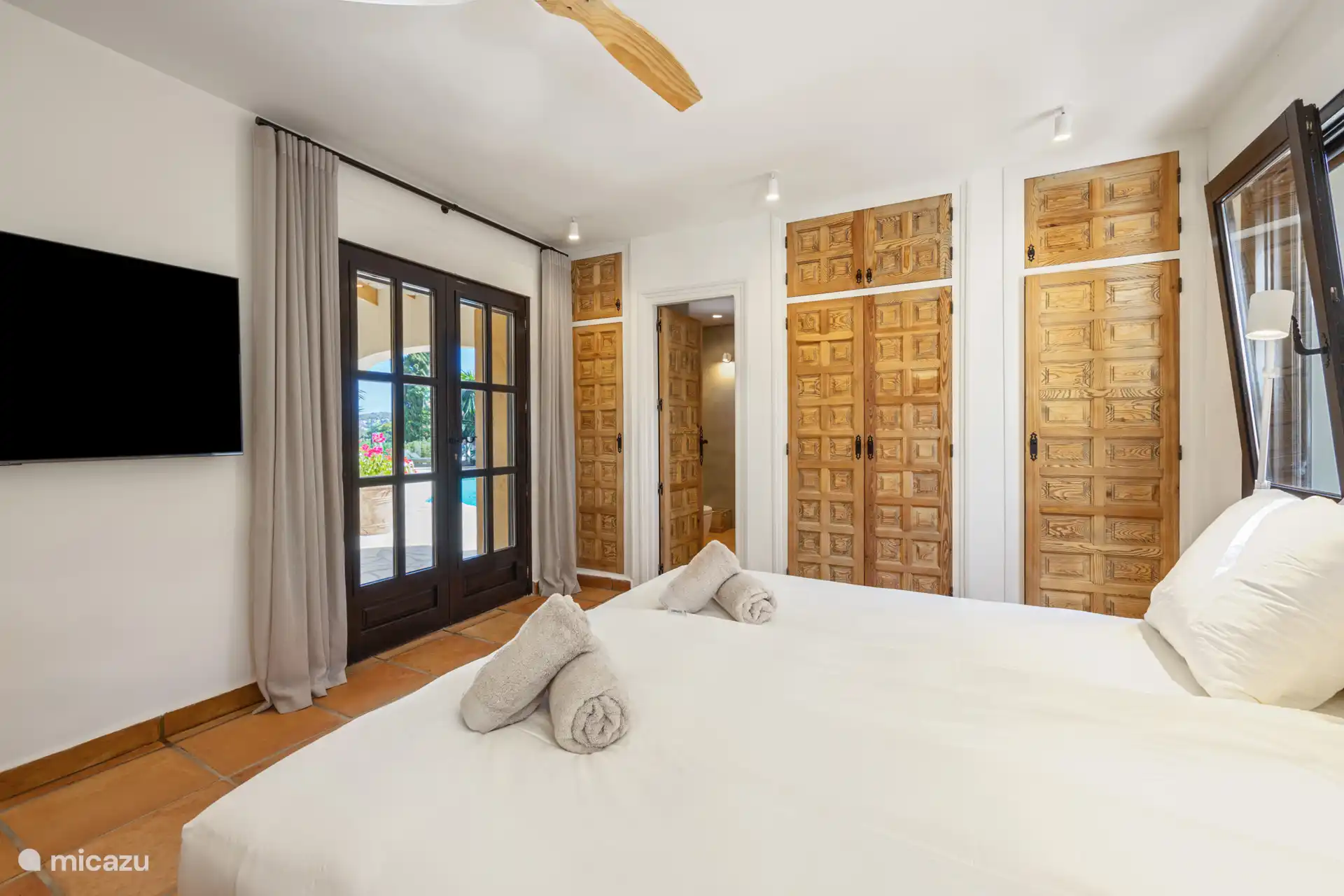 Hoofd slaapkamer met smart televisie en toegnag tot het terras