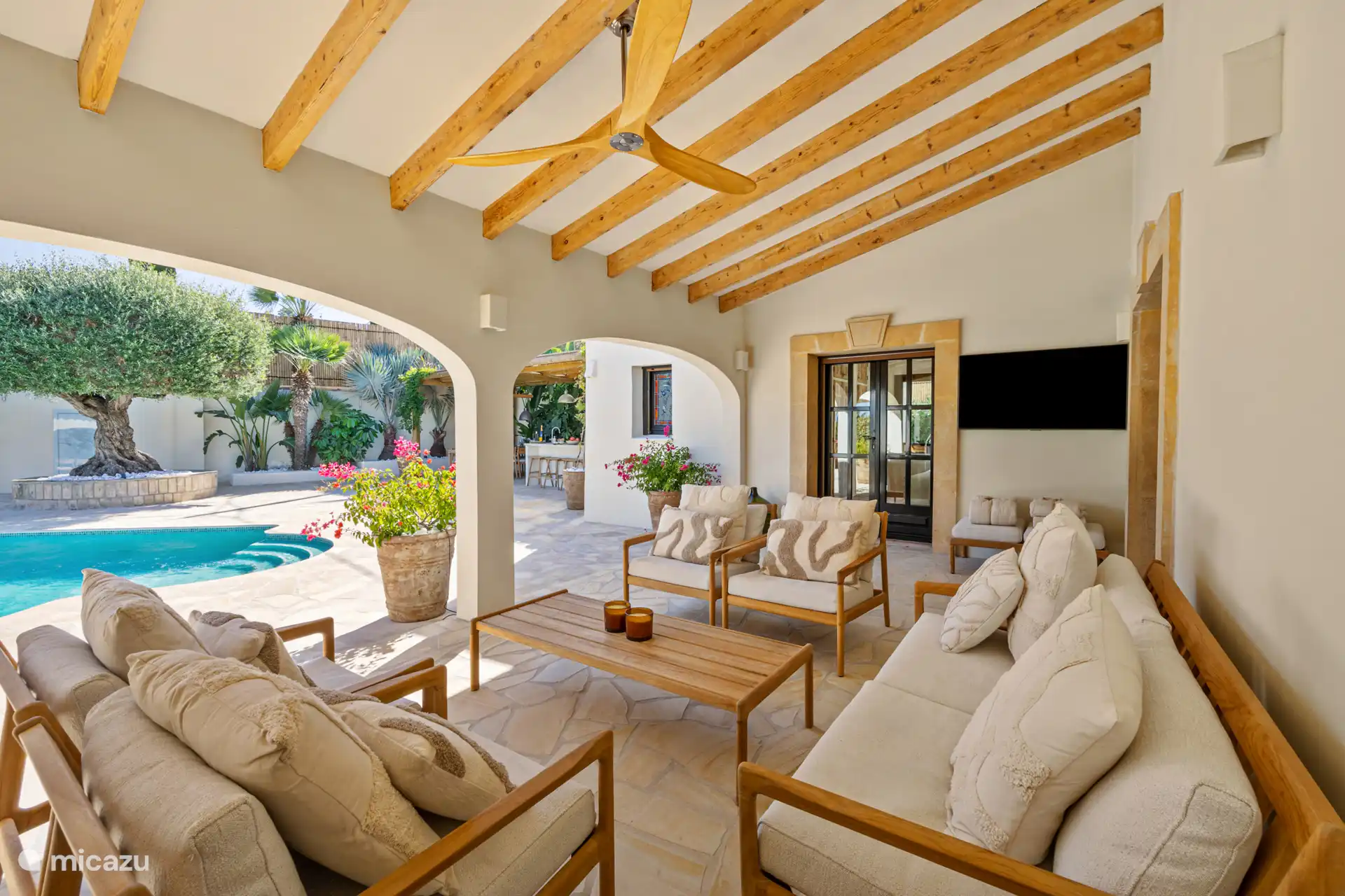 Heelrijk ruim overdekt terras naast het zwembad met comfortabele lounge seat en en buiten televisie (smart). 