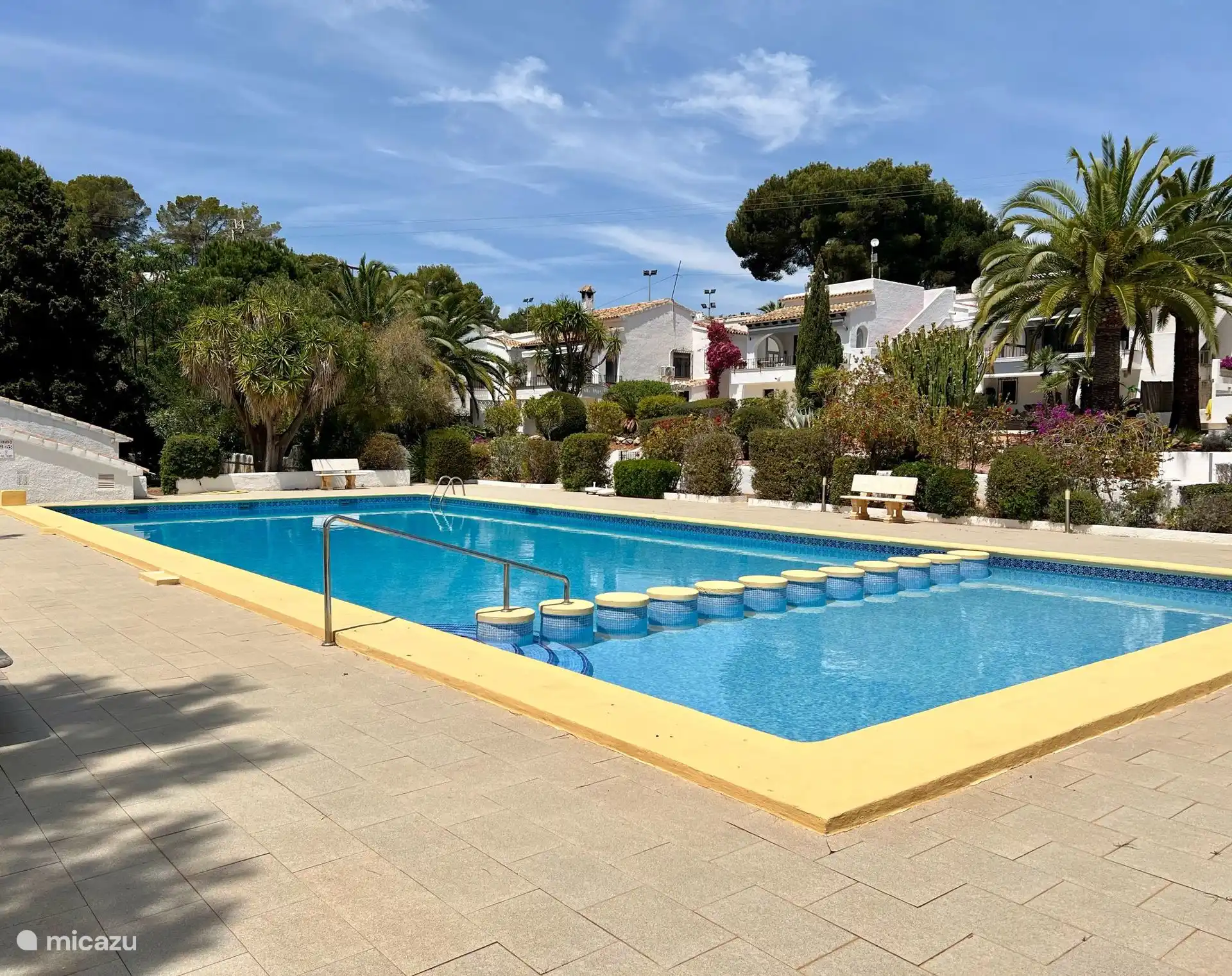 Une jolie grande piscine avec un espace séparé pour enfants.