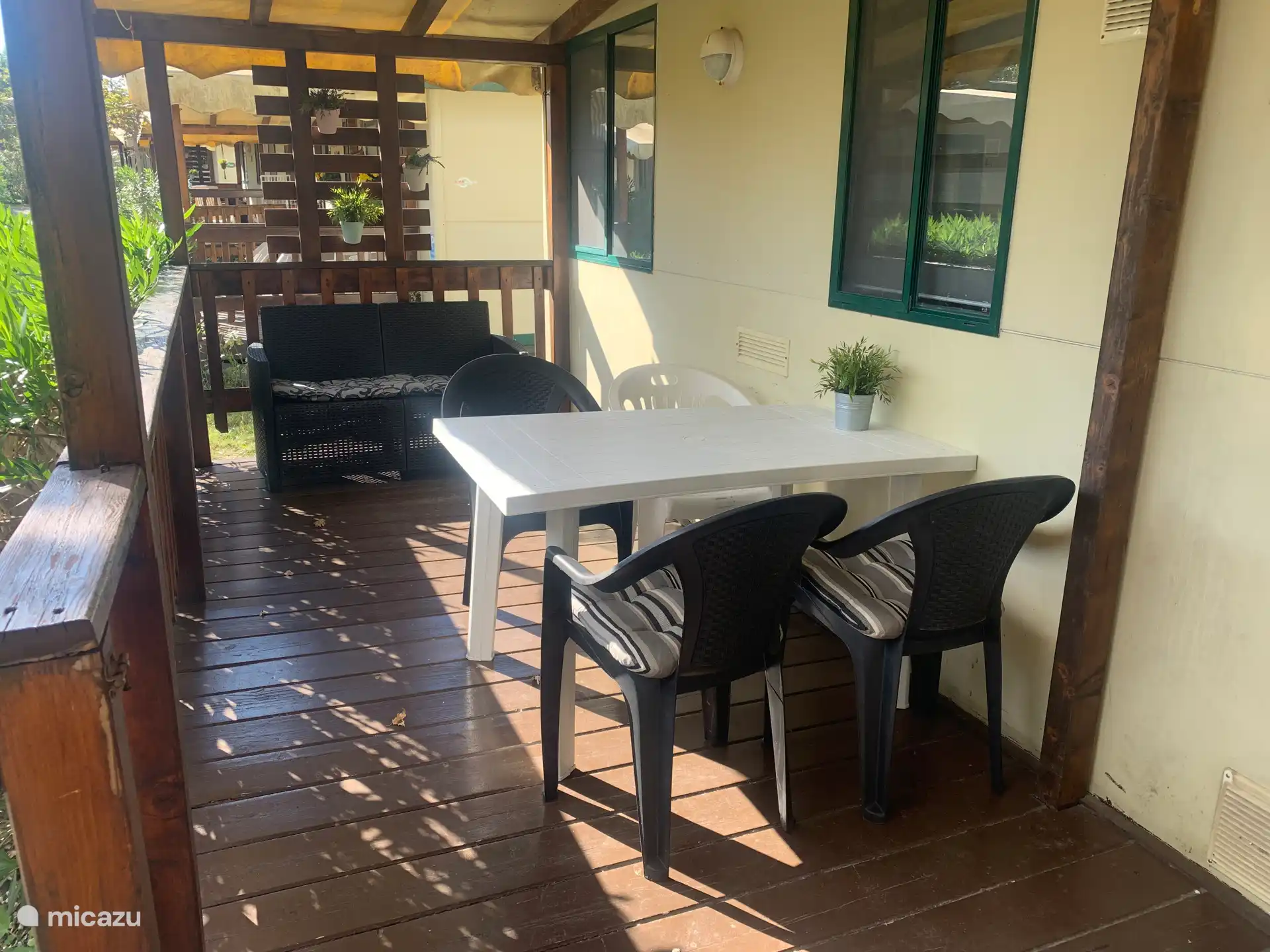 De overdekte veranda met zitbank.