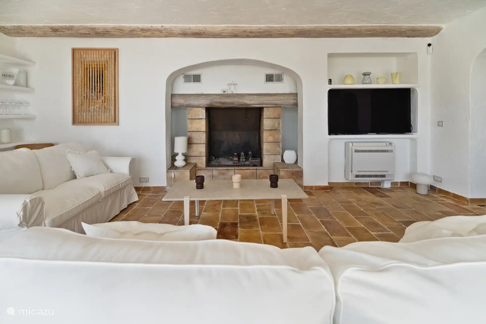 Grote woonkamer met open haard, tv en airco