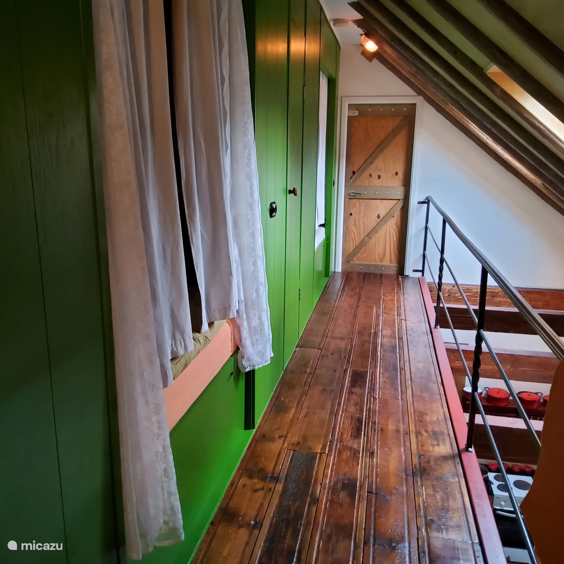 Loft avec 2 lits, entre un placard et une porte menant à l’écurie.