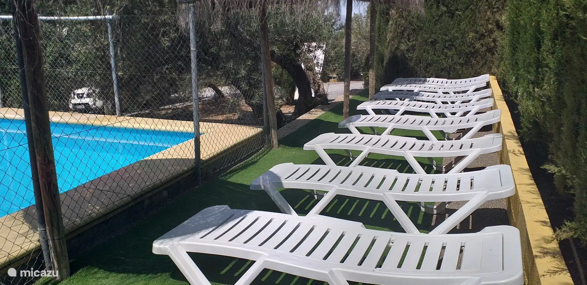 des transats au bord de la piscine. (c’est une photo plus ancienne, la clôture a depuis été retirée)
