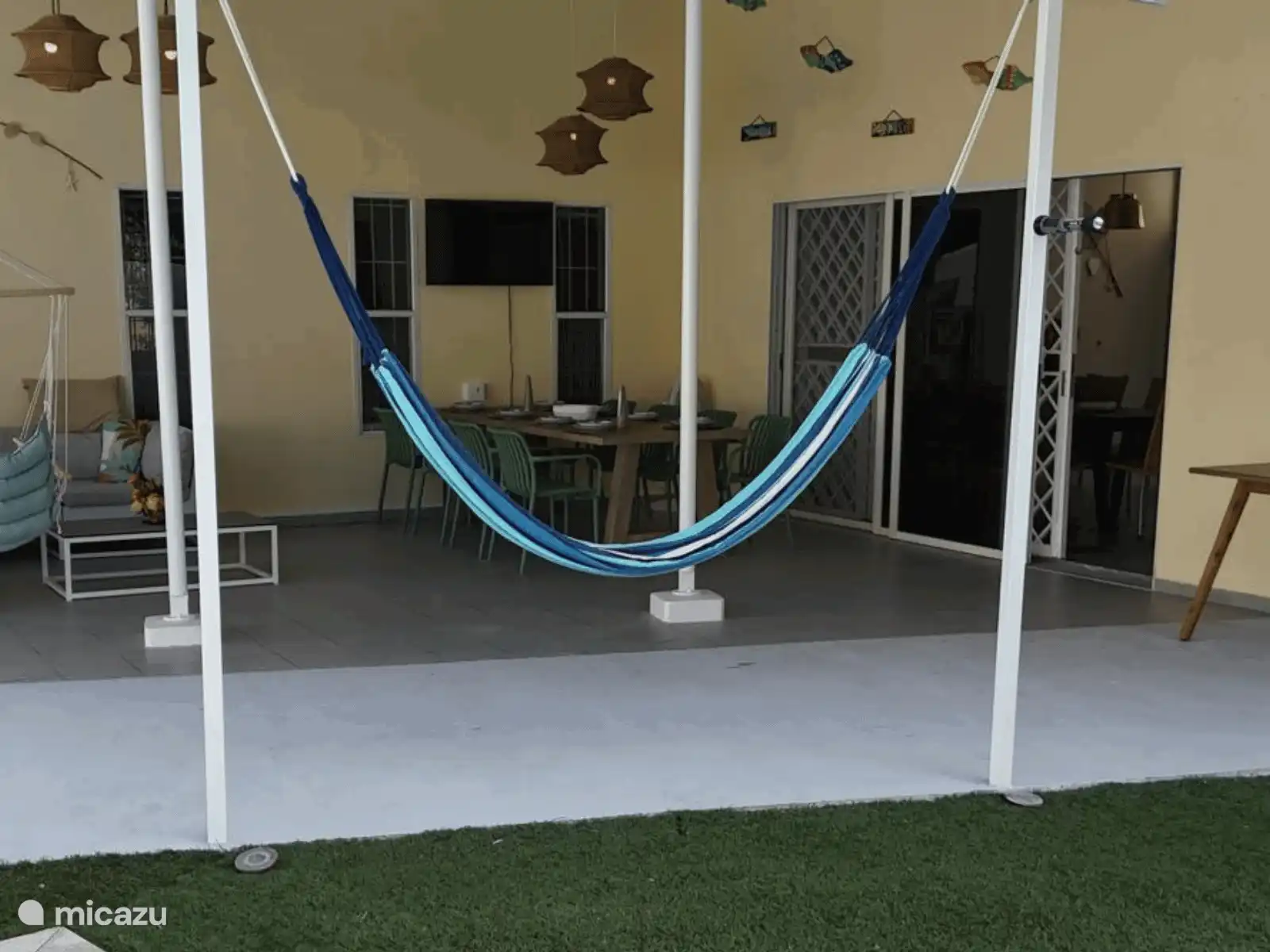 El amplio porche con hamaca y mesa de comedor. Aquí vives al aire libre todo el día, desde el desayuno hasta la cena bajo la brisa caribeña.