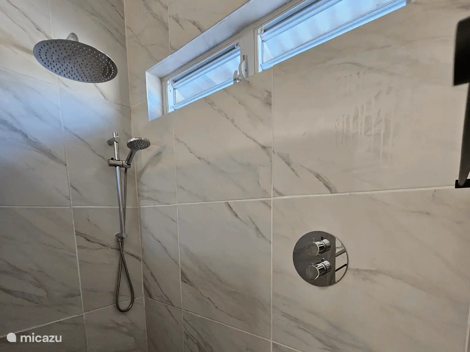 Ducha a pie con ducha de lluvia y acabado elegante. Perfecto para enjuagarse después de la playa y el sol.