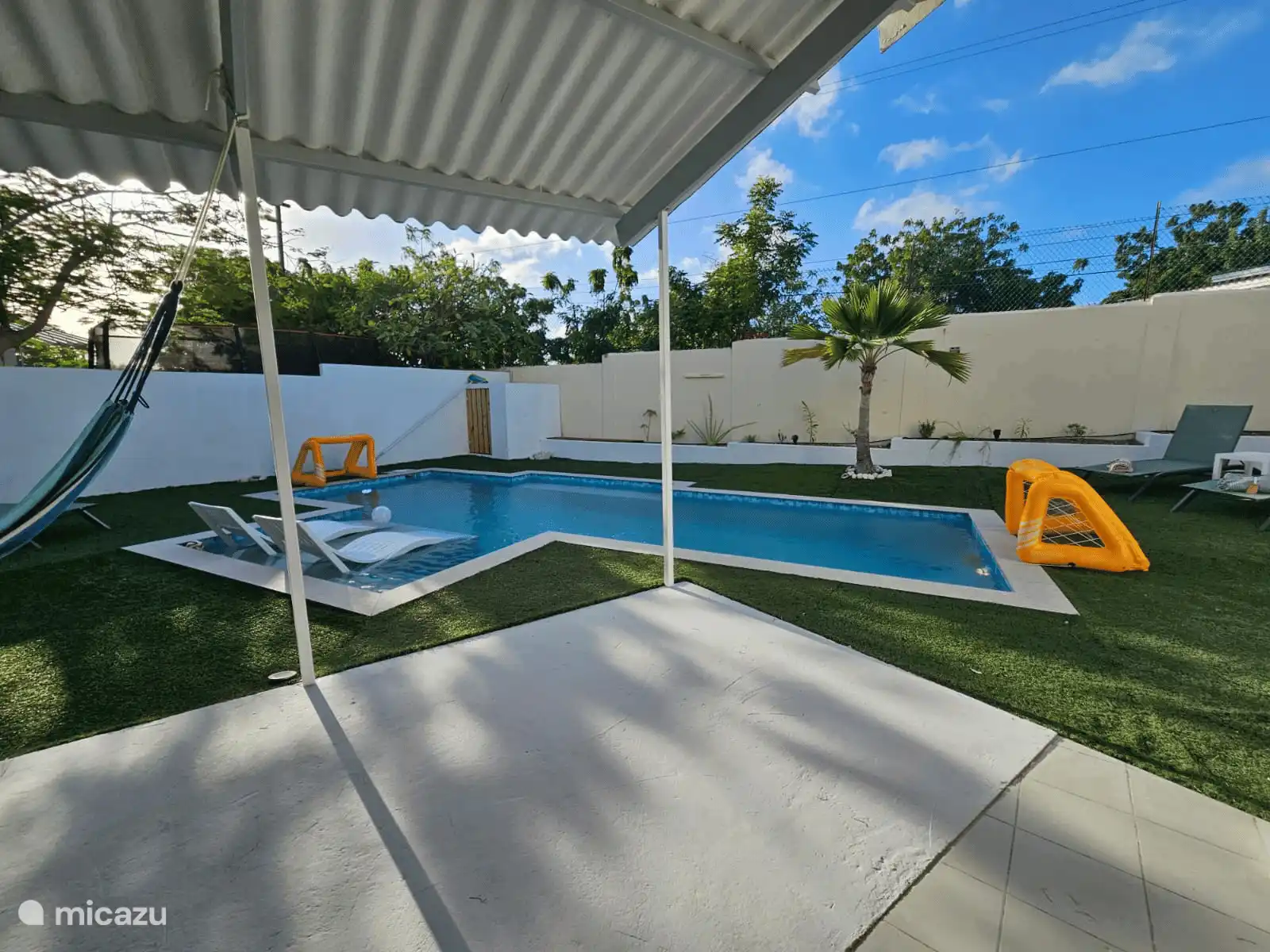 Vista desde el porche hacia la piscina y el jardín. Mucho espacio, tranquilidad y varios lugares para descansar al sol o a la sombra.