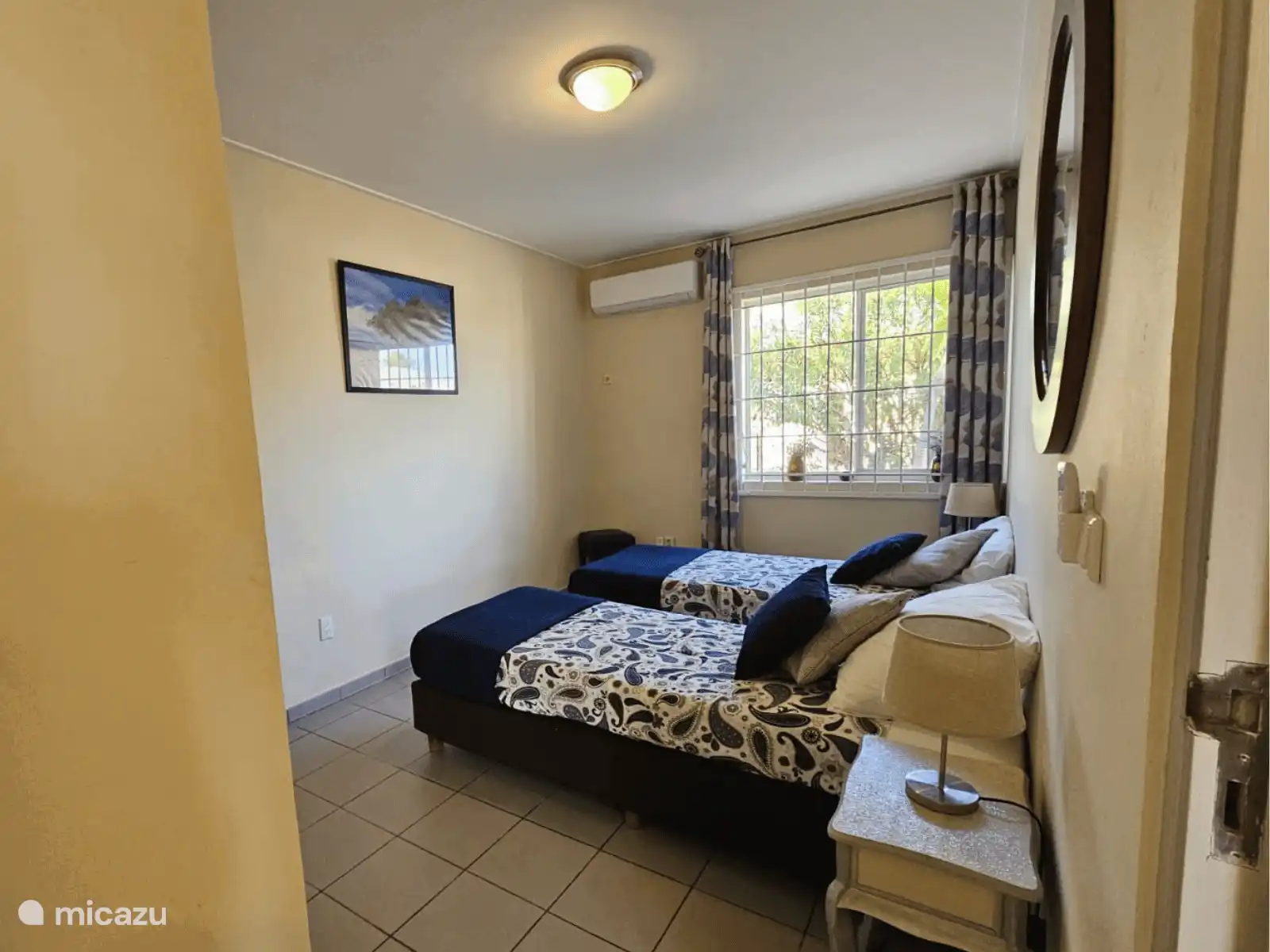 Dormitorio con dos camas individuales cómodas y aire acondicionado. Decorado en silencio, agradable para dormir bien.