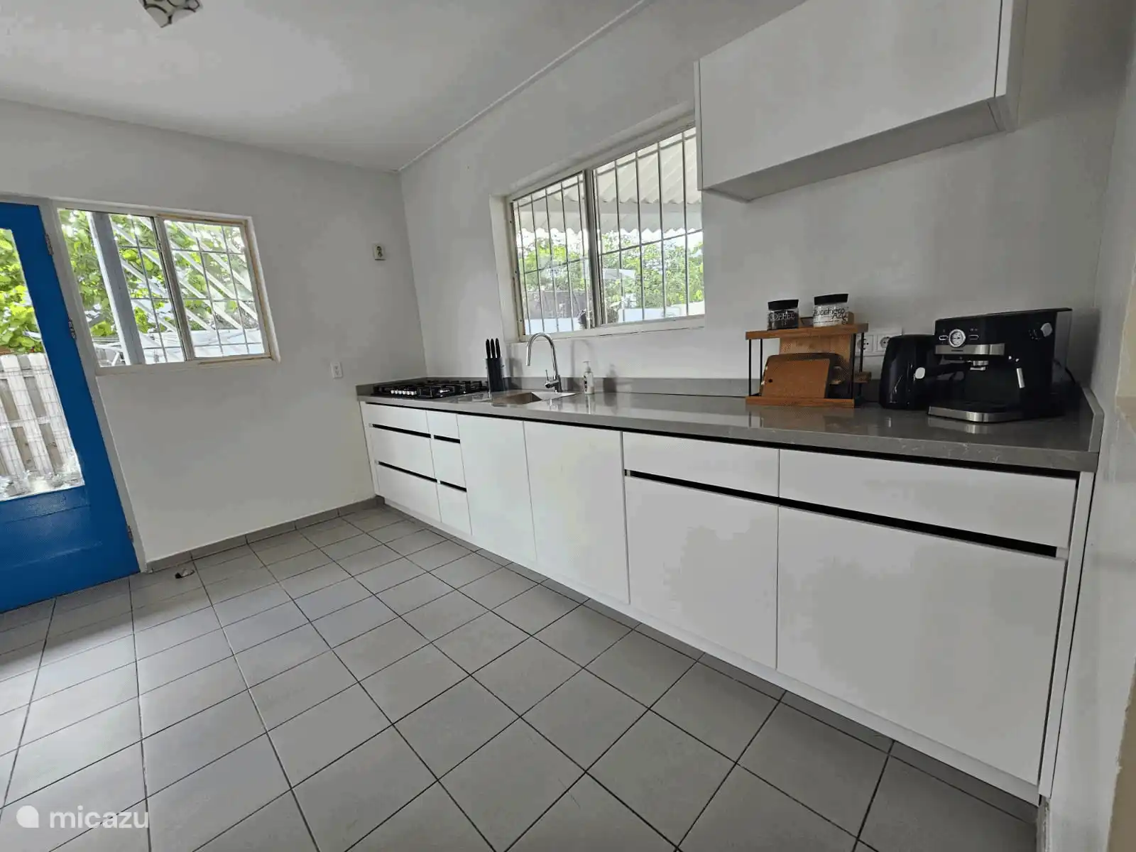 Cocina espaciosa y moderna con mucha encimera, cocina de gas de 5 quemadores y acceso directo al exterior. Ideal para cocinar y disfrutar juntos.