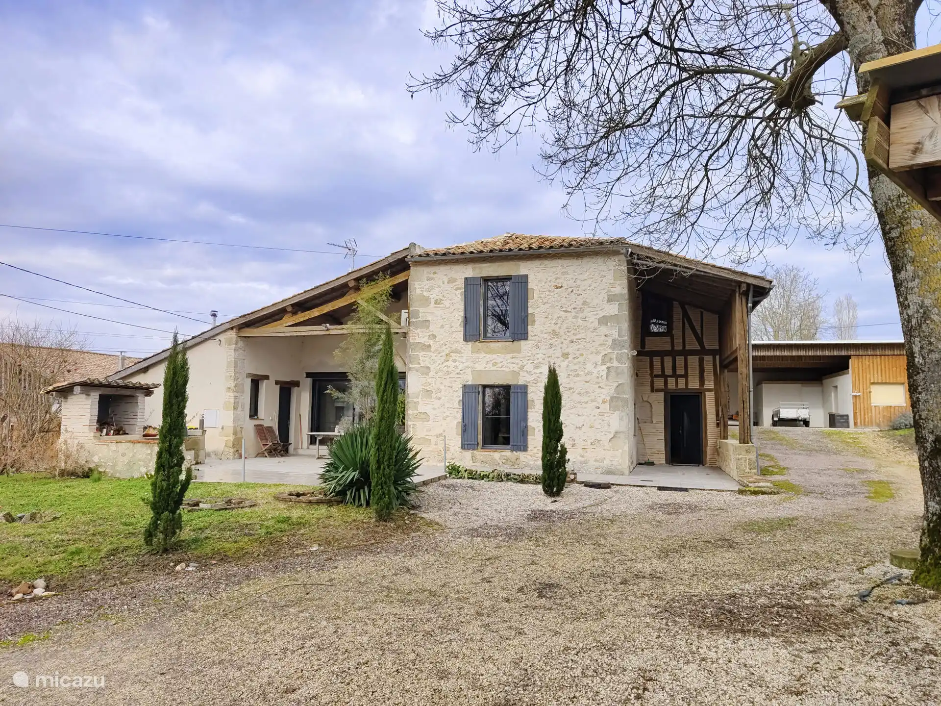 La maison avec terrasse couverte et barbecue